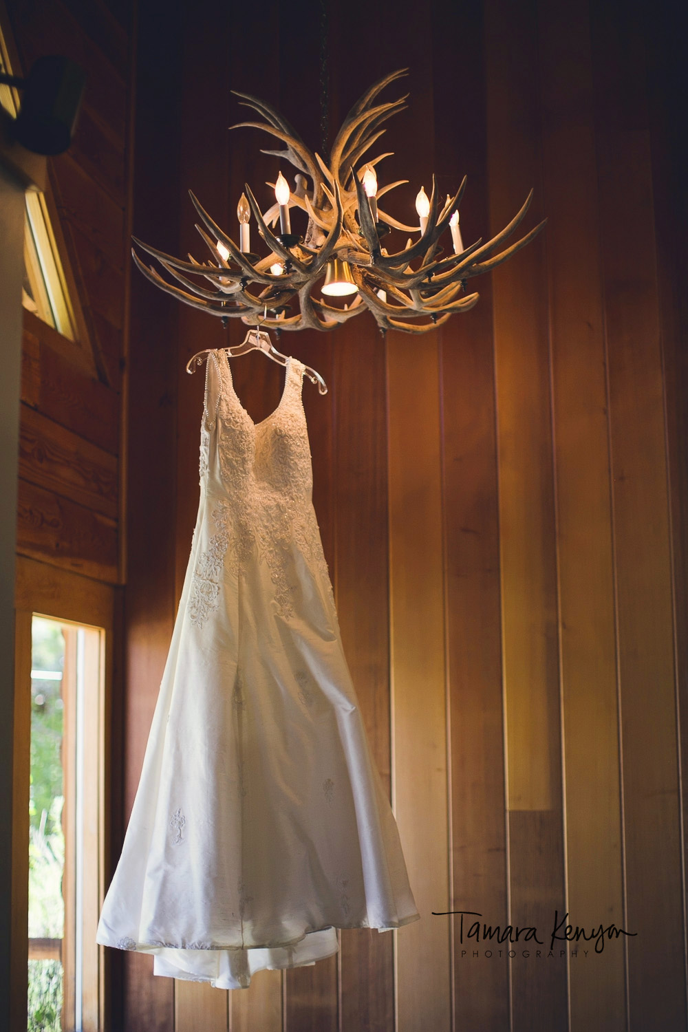 wedding dress hanging from antler chandelier