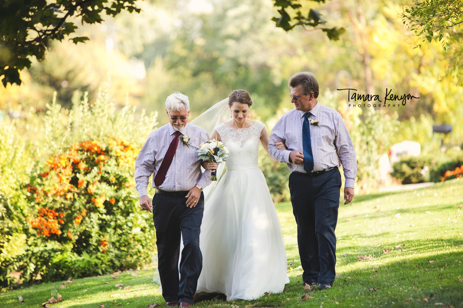 father and stepdad walking daughter down the aisle