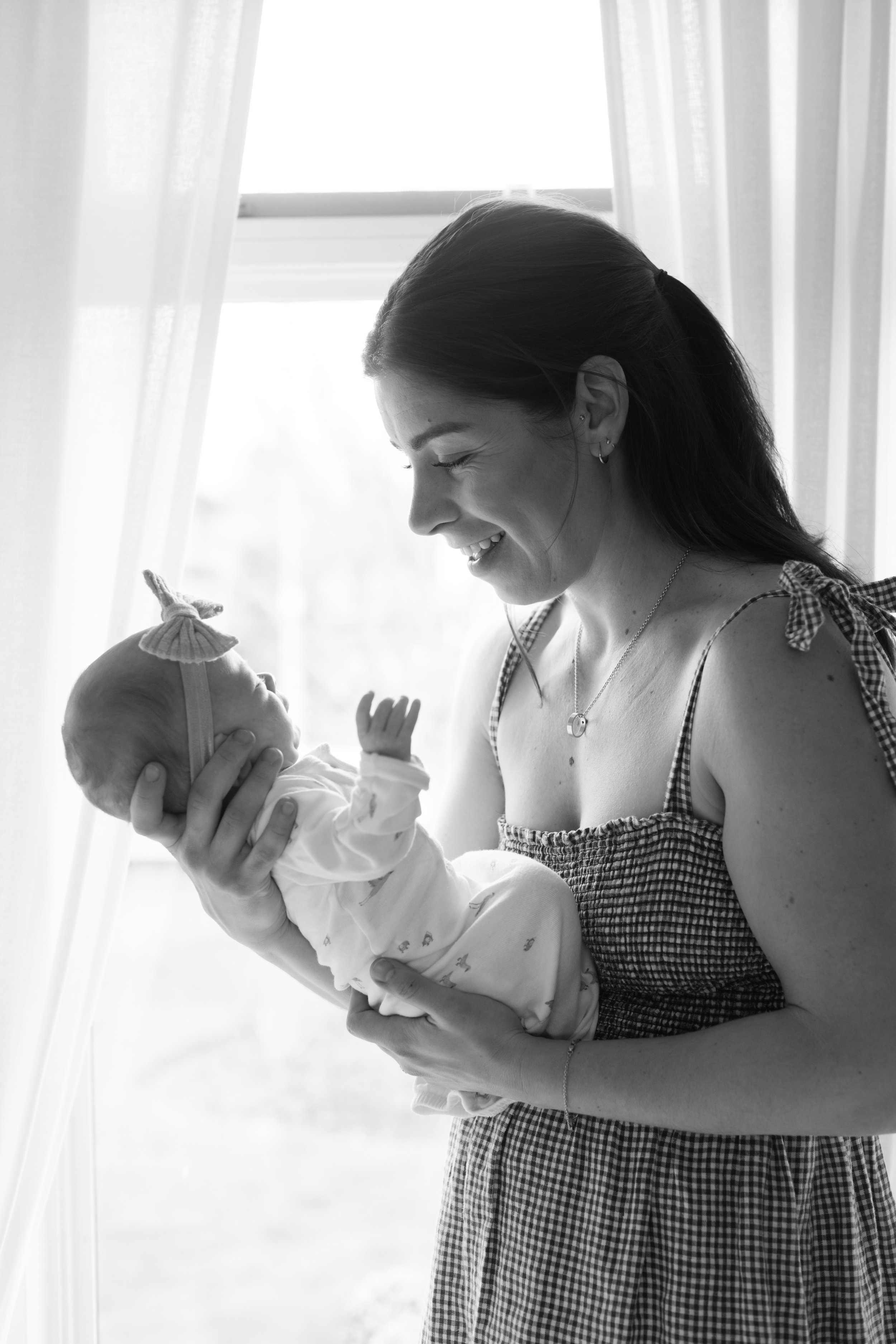 mom-holding-newborn-next-to-window.jpg