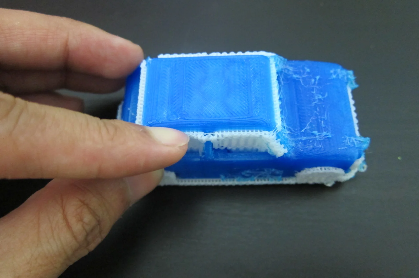 2 using hands to cut off support filament