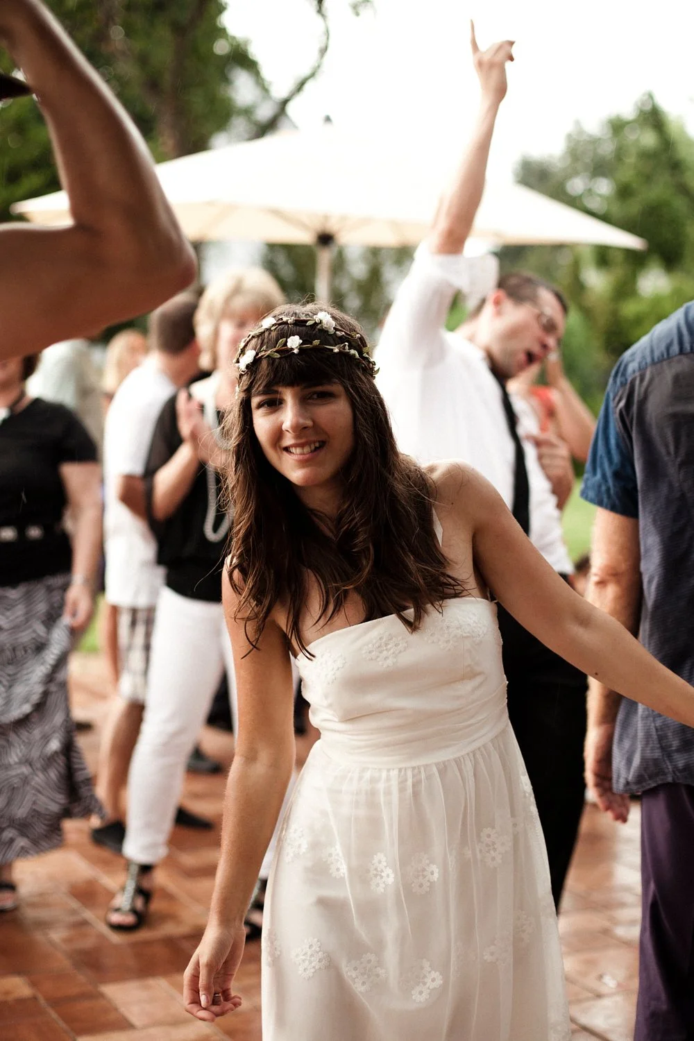 Bride dancing with wedding guests in the background.
