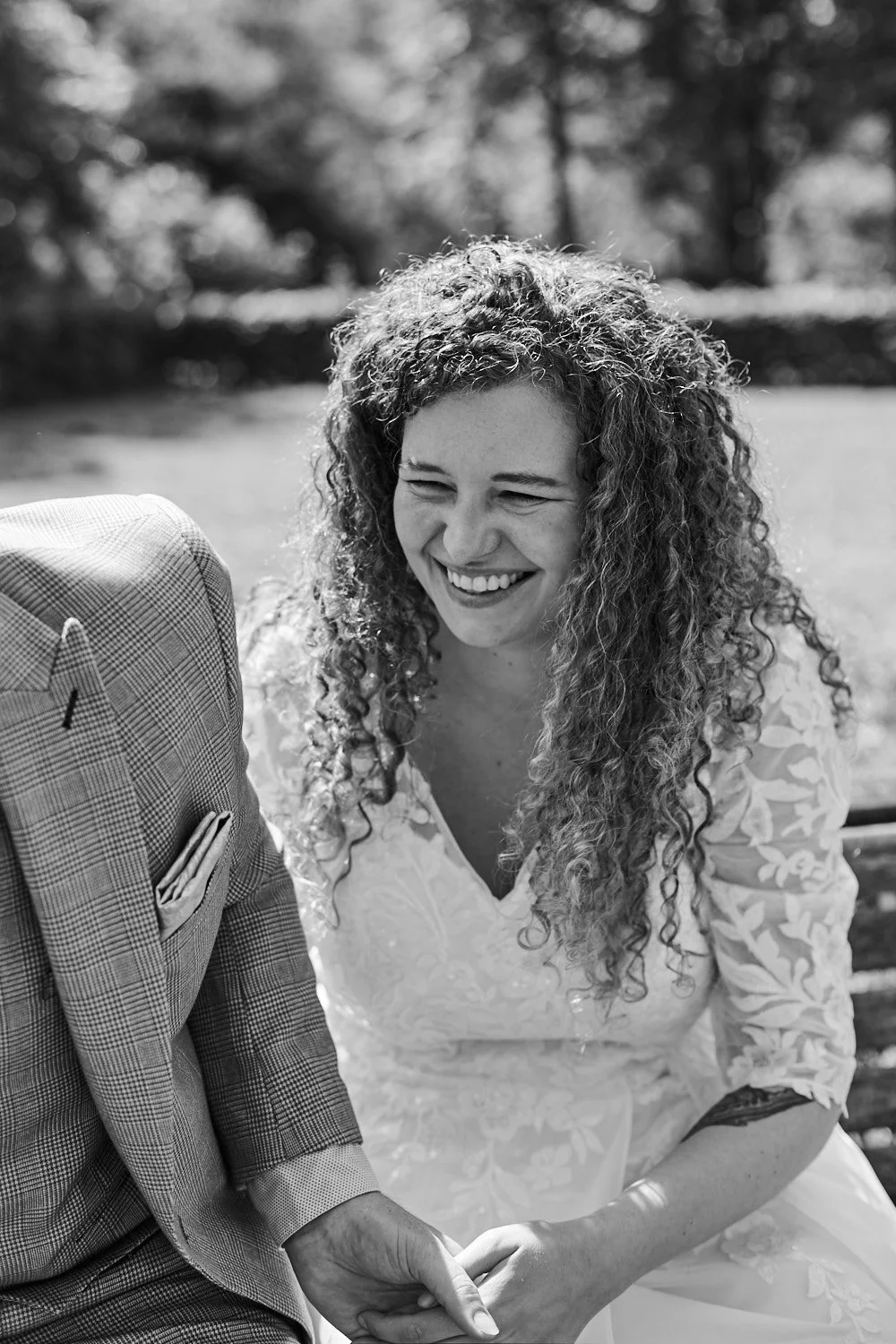Young bride with curly hair laughing.
