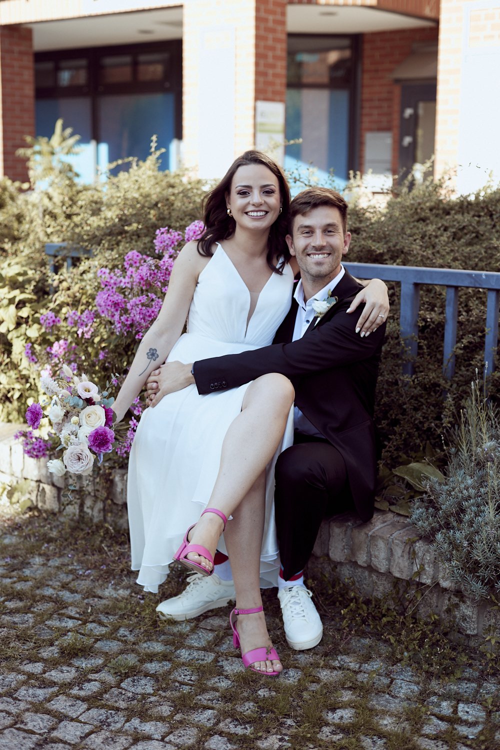 Bride sitting on groom's knees.