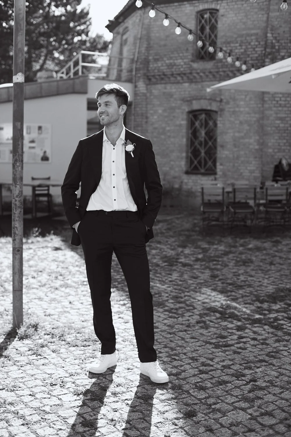 Full body portrait of a groom looking to the side.
