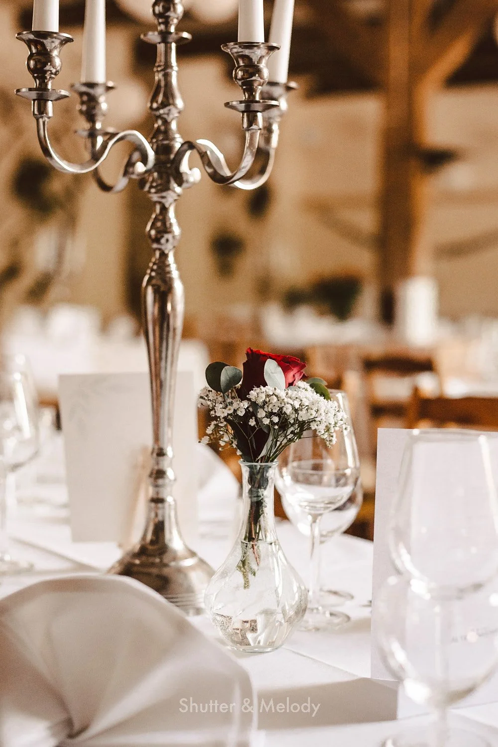 Decorative flowers on a table next to a candelabra.