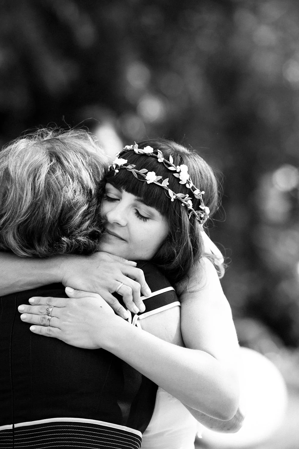 Bride hugging mother after wedding ceremony.