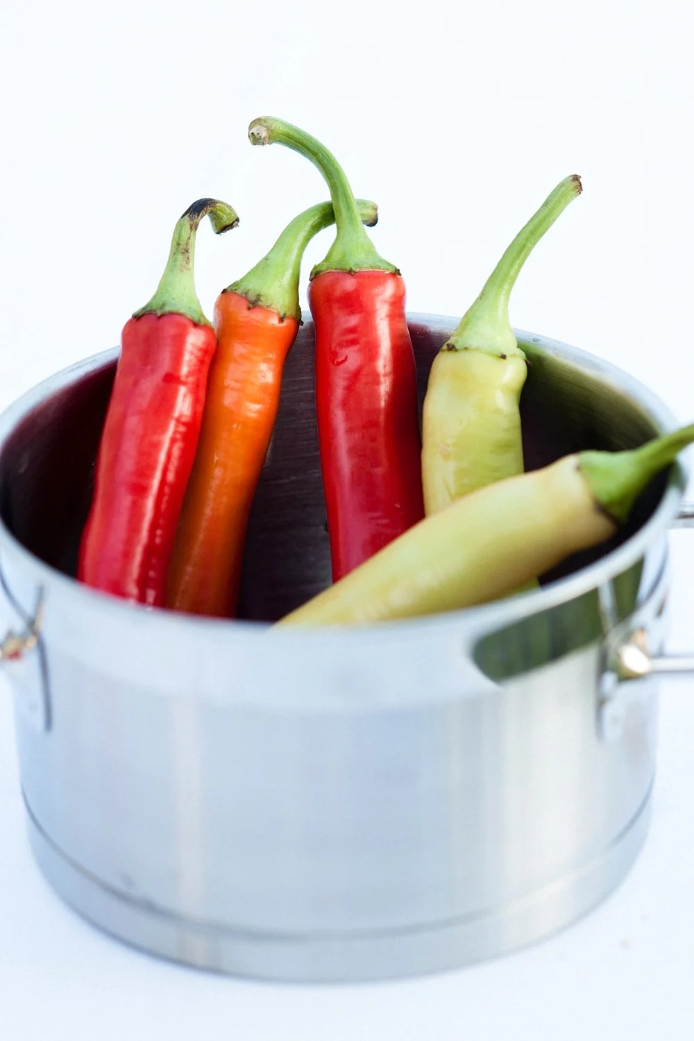 Chilli peppers in a small stainless pot.