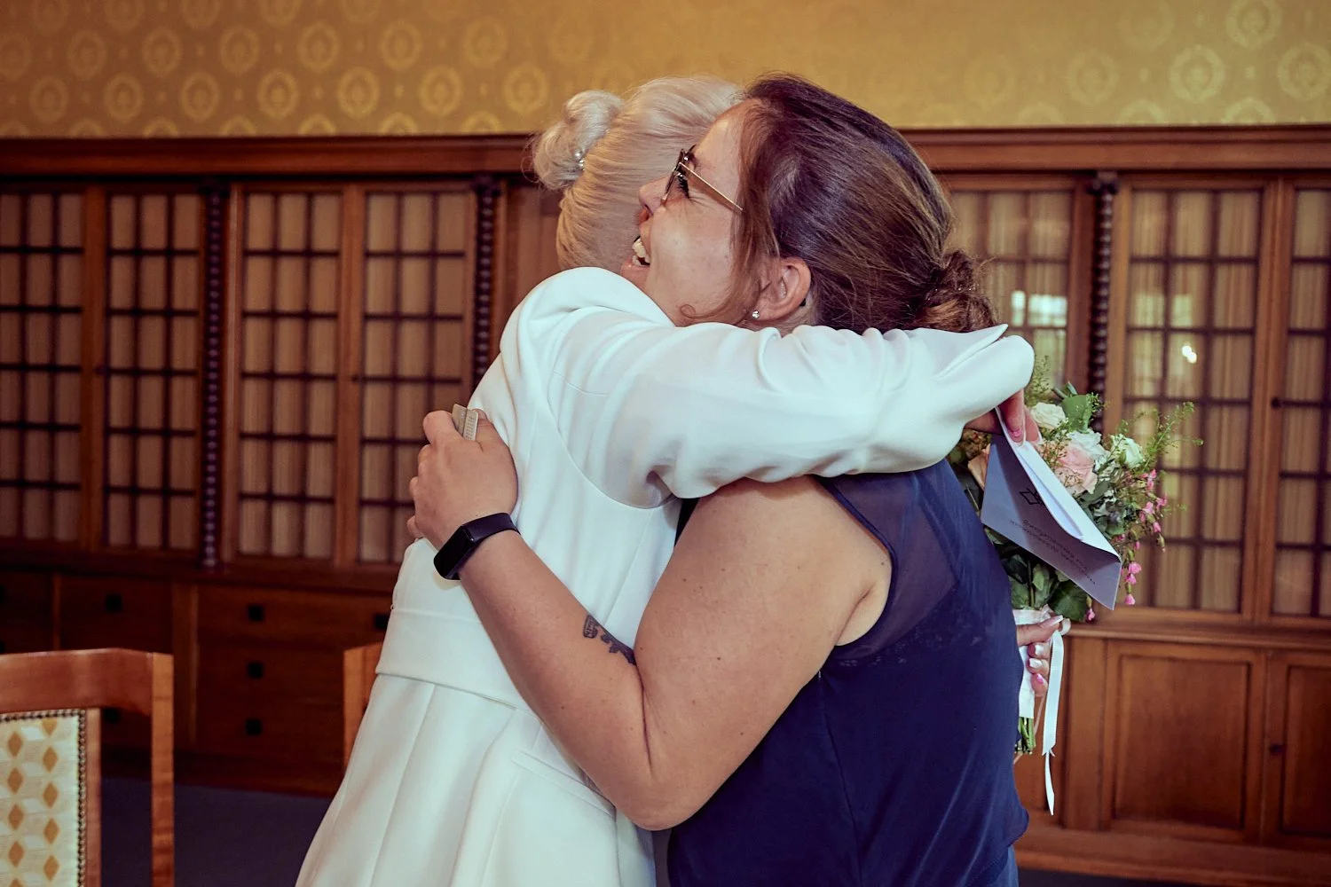 Bride hugging guest after wedding ceremony.