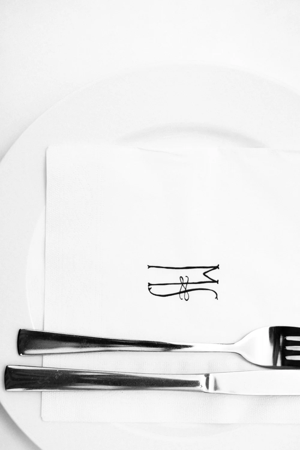 A plate with a monogram and cutlery.
