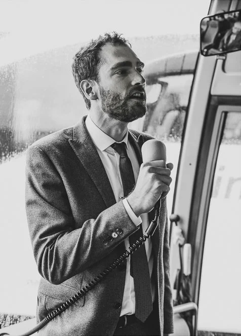 A groom speaking over a microphone on a bus.