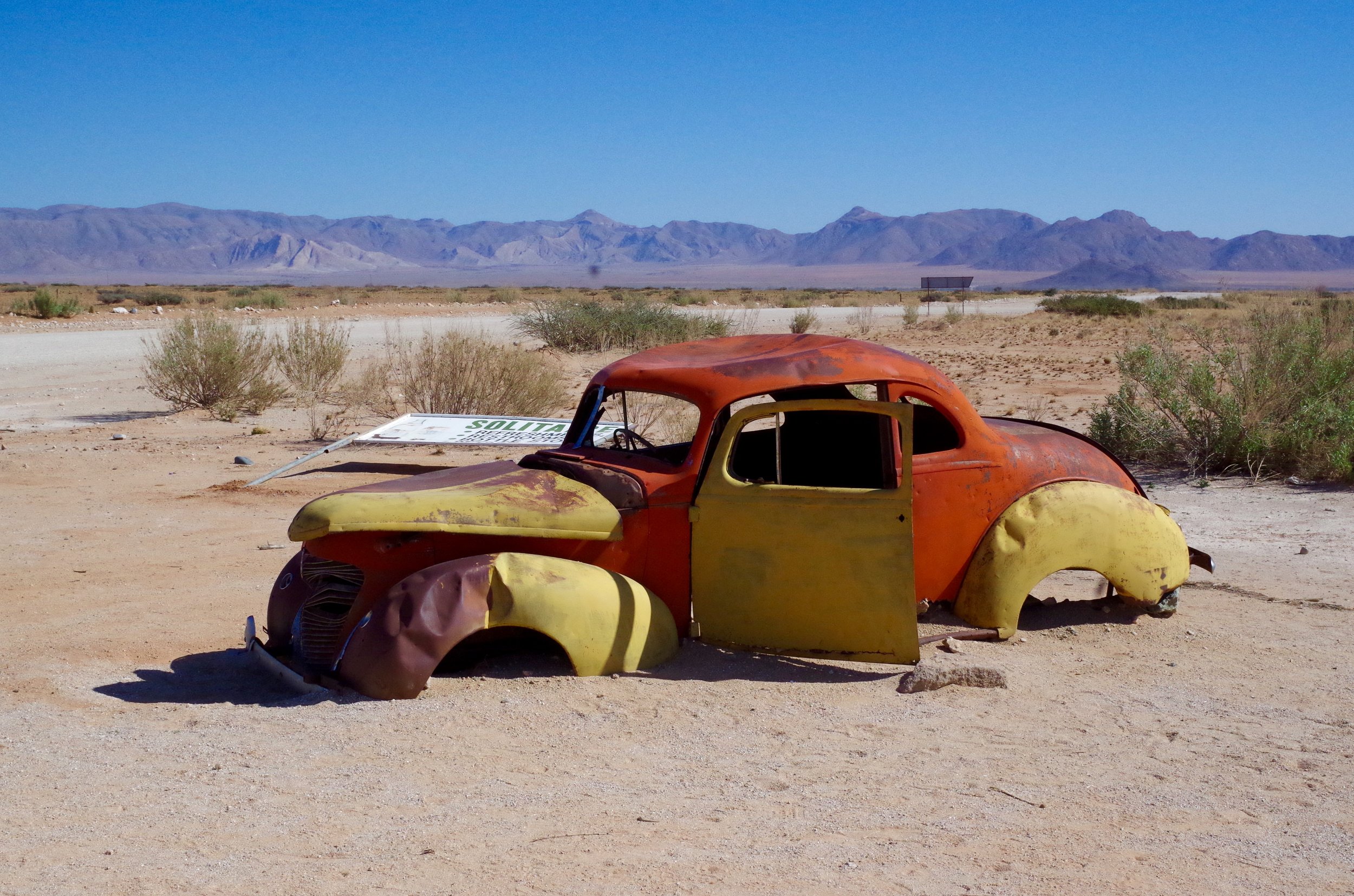 Bust An old car is left for scrap in the dust. We came across hundreds of broken down cars and jeeps along the desert highways in a somewhat Route 66 dystopian landscape.
