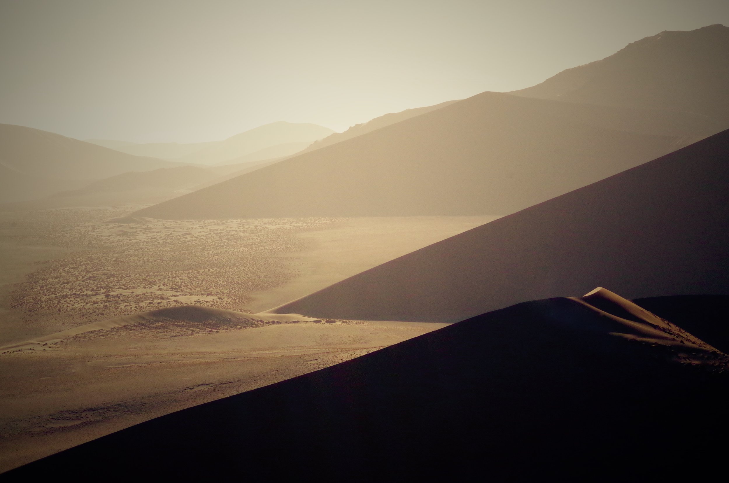 Haze Sharp angled dunes rise up from the barren plains below. An empty land of heat and sand. The windswept hills are prone to sand storms and visibility is often poor.