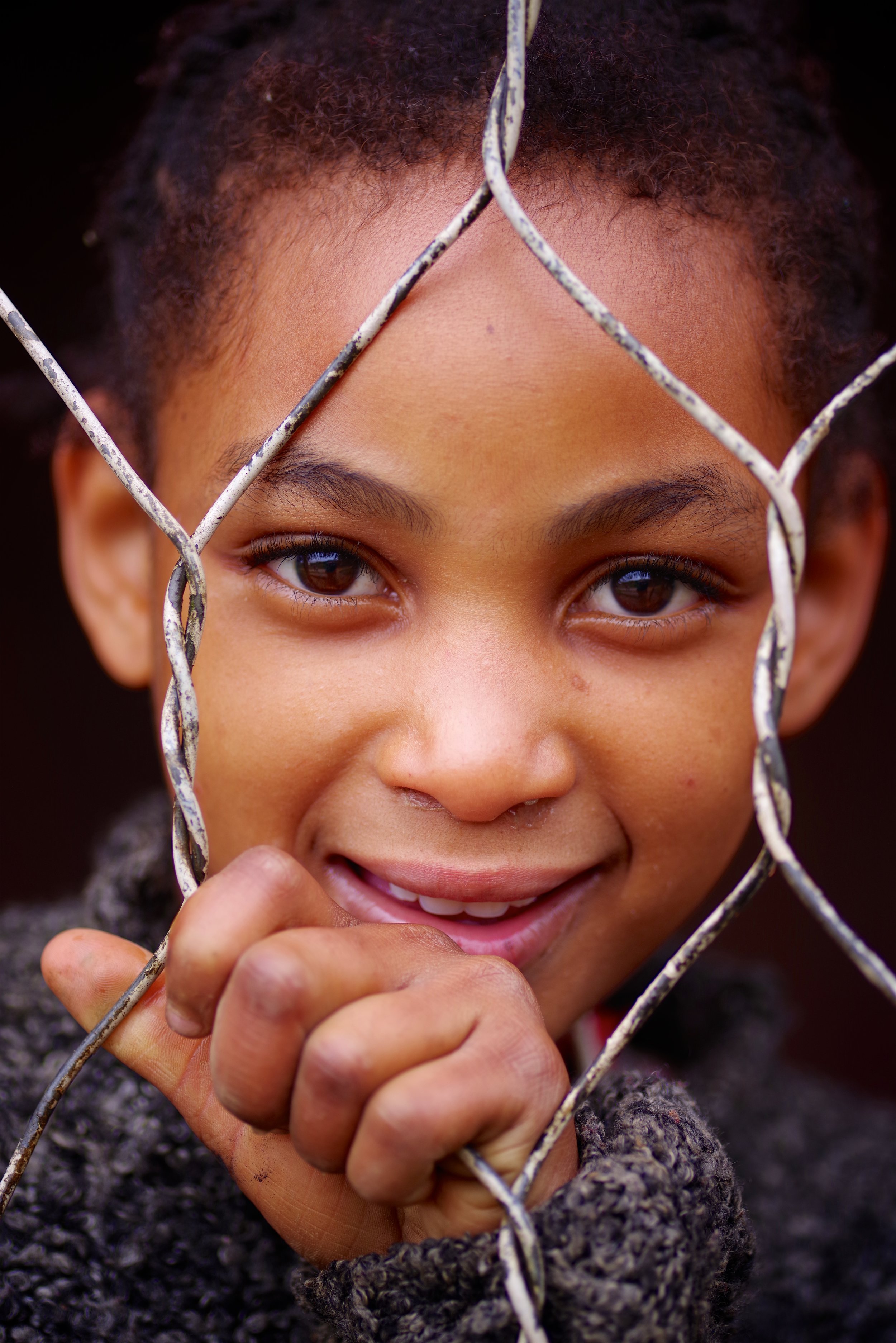 Fosiah We met this young girl, waiting eagerly for her brothers to arrive from school, behind a wire fence in the village of Ranomafana.