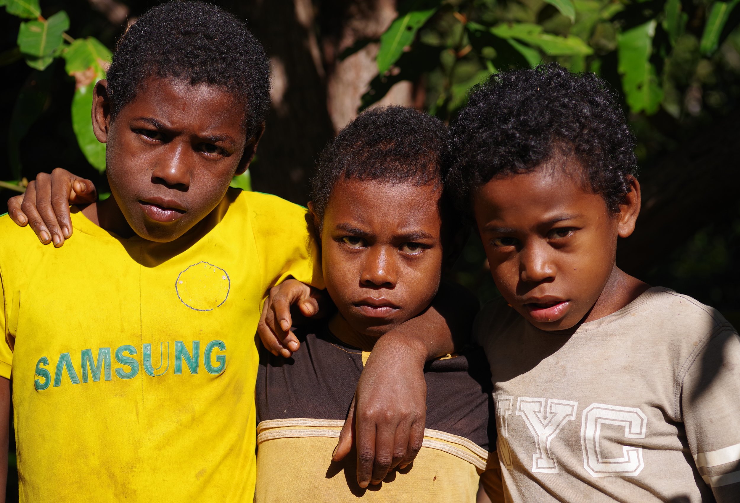 Team of Three Boys take a break from their football game to snap a photograph together.