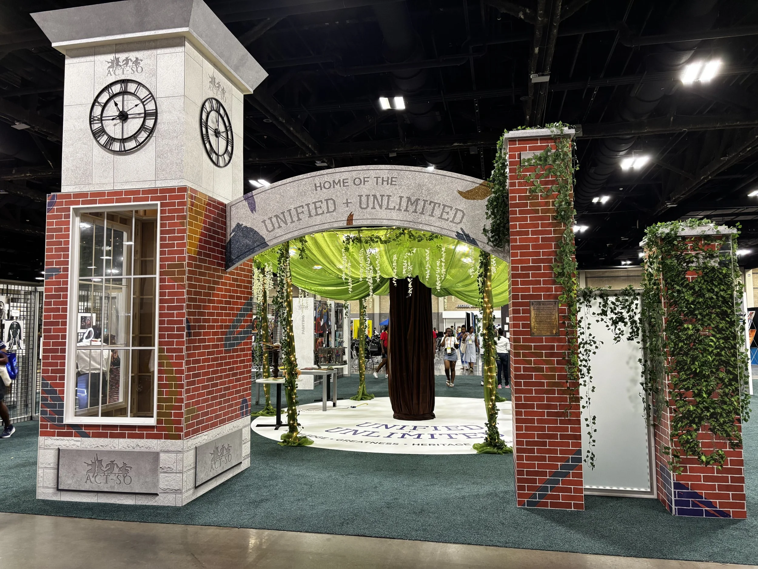  The entrance to the ACT-SO Courtyard was designed to evoke the classic architecture and atmosphere of an Ivy League campus. Built from beMatrix frames and SEG fabric panels, the structure featured a clock tower draped in faux ivy and accented with s