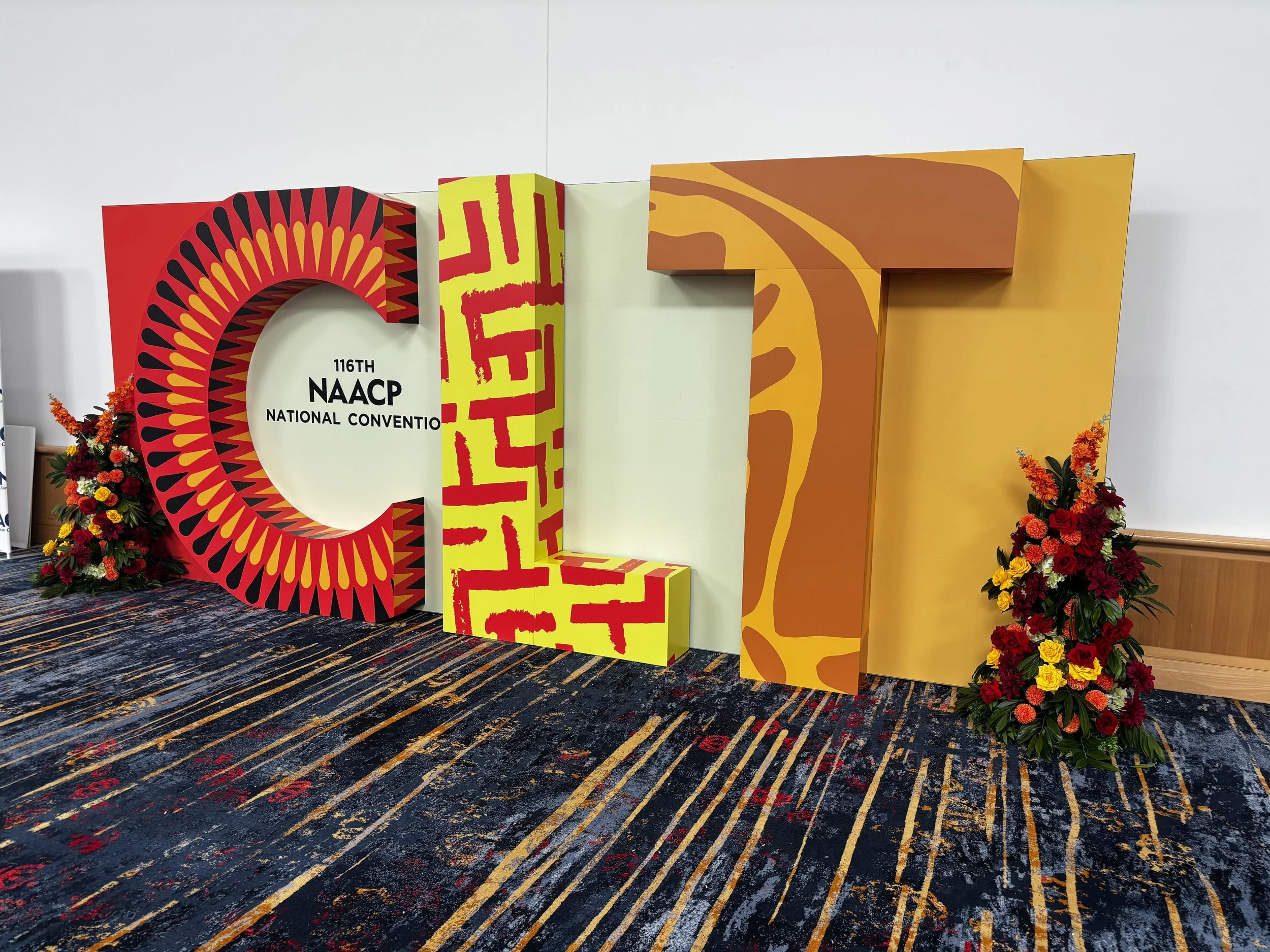  Greeting attendees at the entrance, the bold eight-foot-tall “CLT” letters served as a vibrant tribute to the host city of Charlotte. Wrapped in colorful, patterned graphics inspired by traditional African textiles, the installation set the tone for