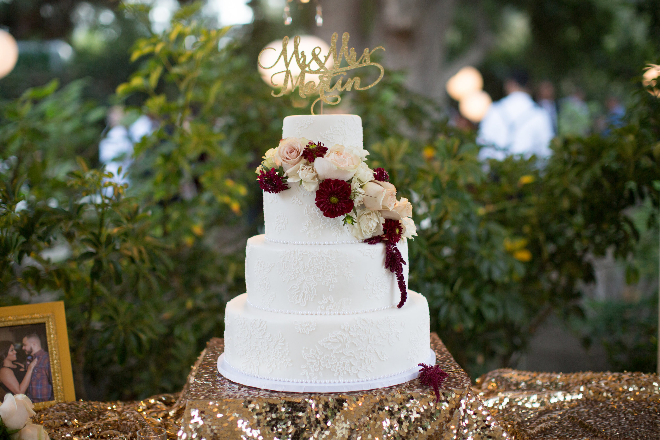 Intricate lace and merlot floral cake by Singer Sisters Sweets. 