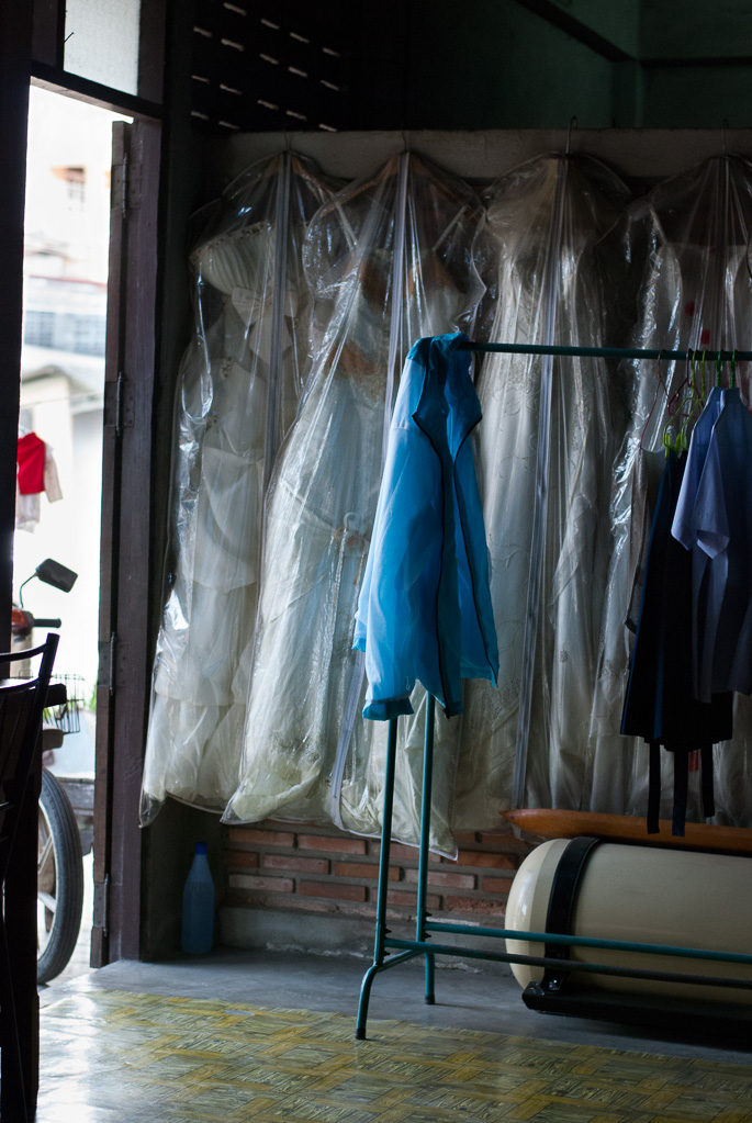White wedding dresses hang in open doorway, Thasala