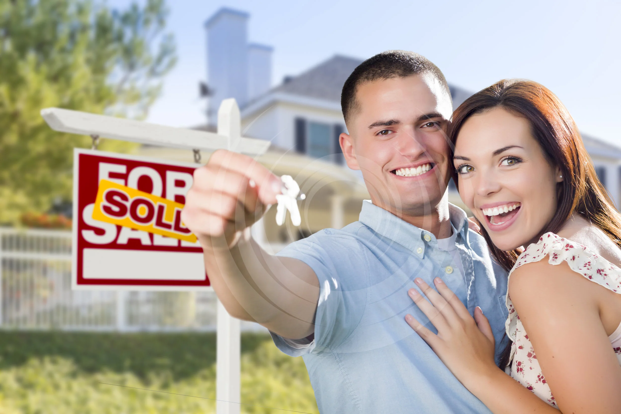   Mixed Race Excited Military Couple In Front of New Home with New House Keys and Sold Real Estate Sign Outside.  