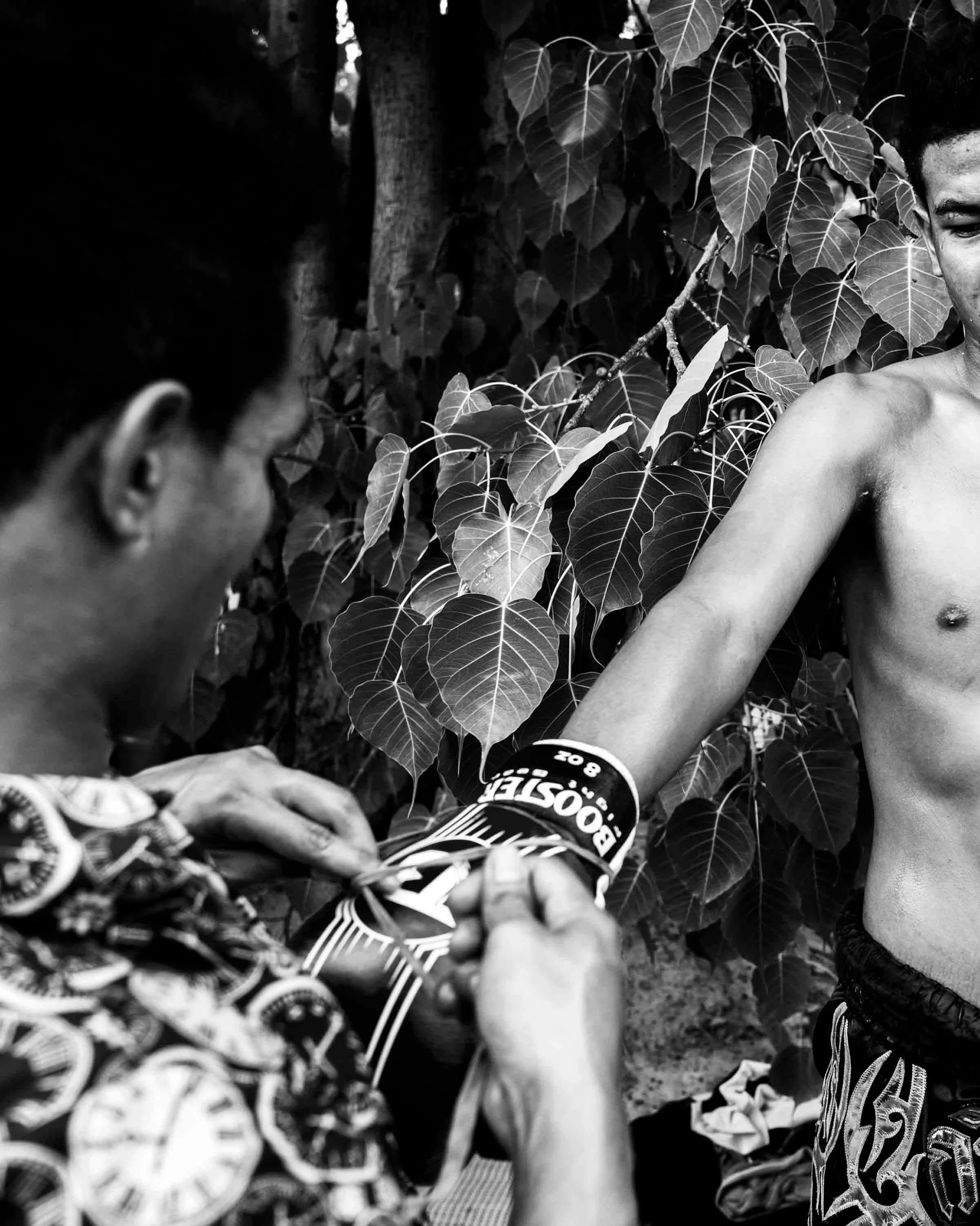 A fighter is in a determined mood as his gloves are laced up before his fight in Isaan. #muaythai