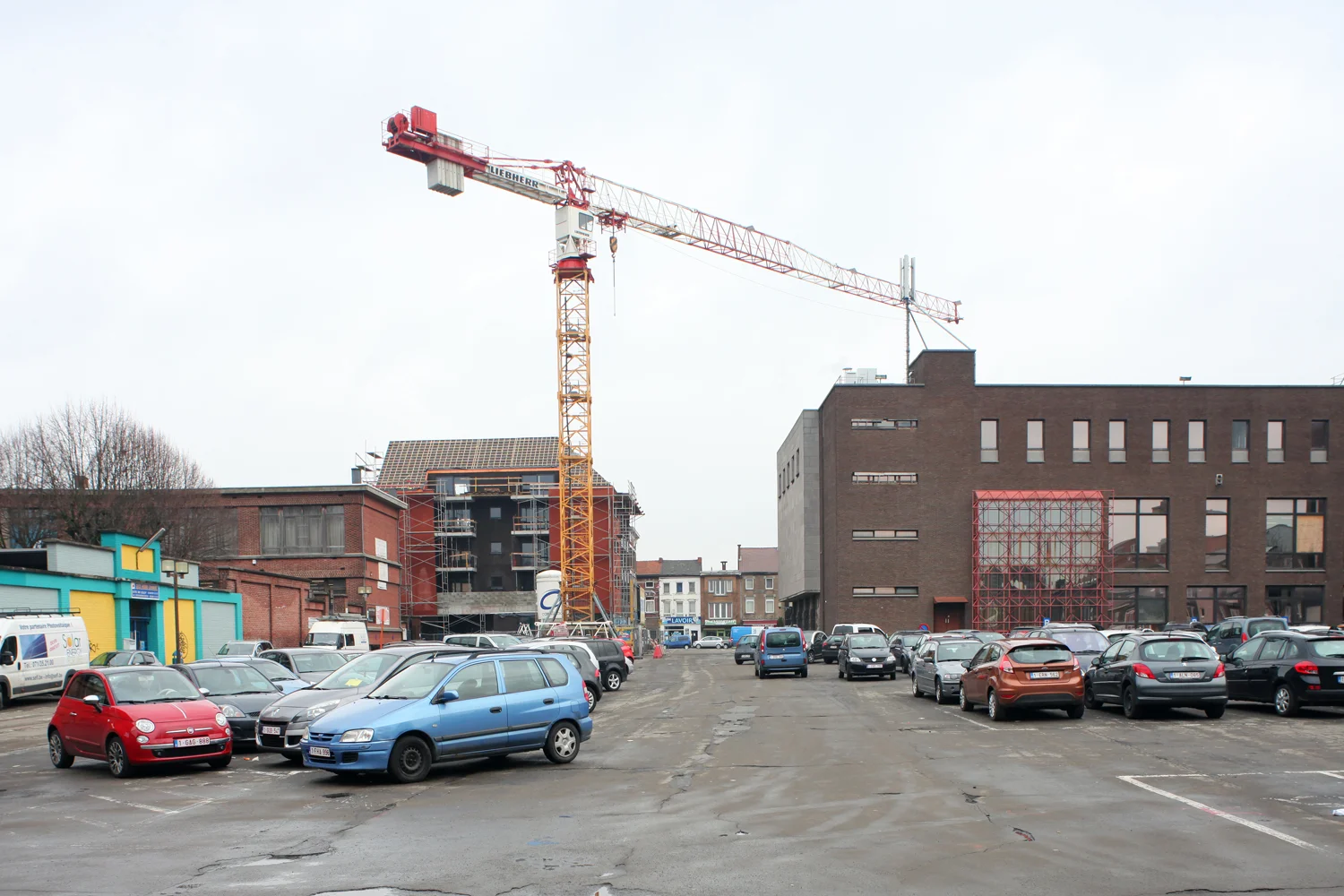 Vue depuis le parking vers la Place Destrée et la Chaussée de Lodelinsart. A droite, la Maison communale annexe, à gauche les accès aux établissements scolaires (photographe: Maxime Delvaux ).