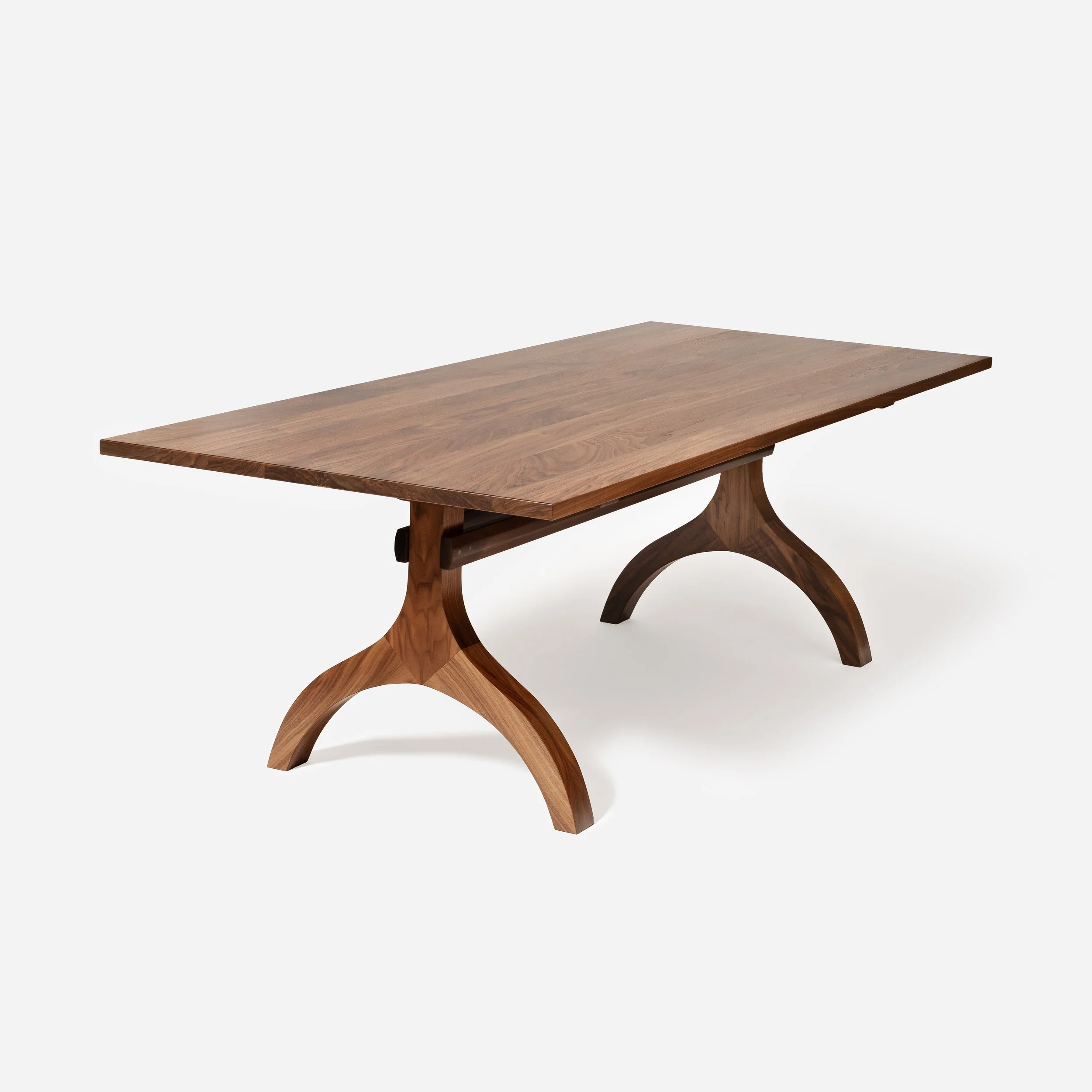 A full three-quarter studio shot of a solid walnut dining table