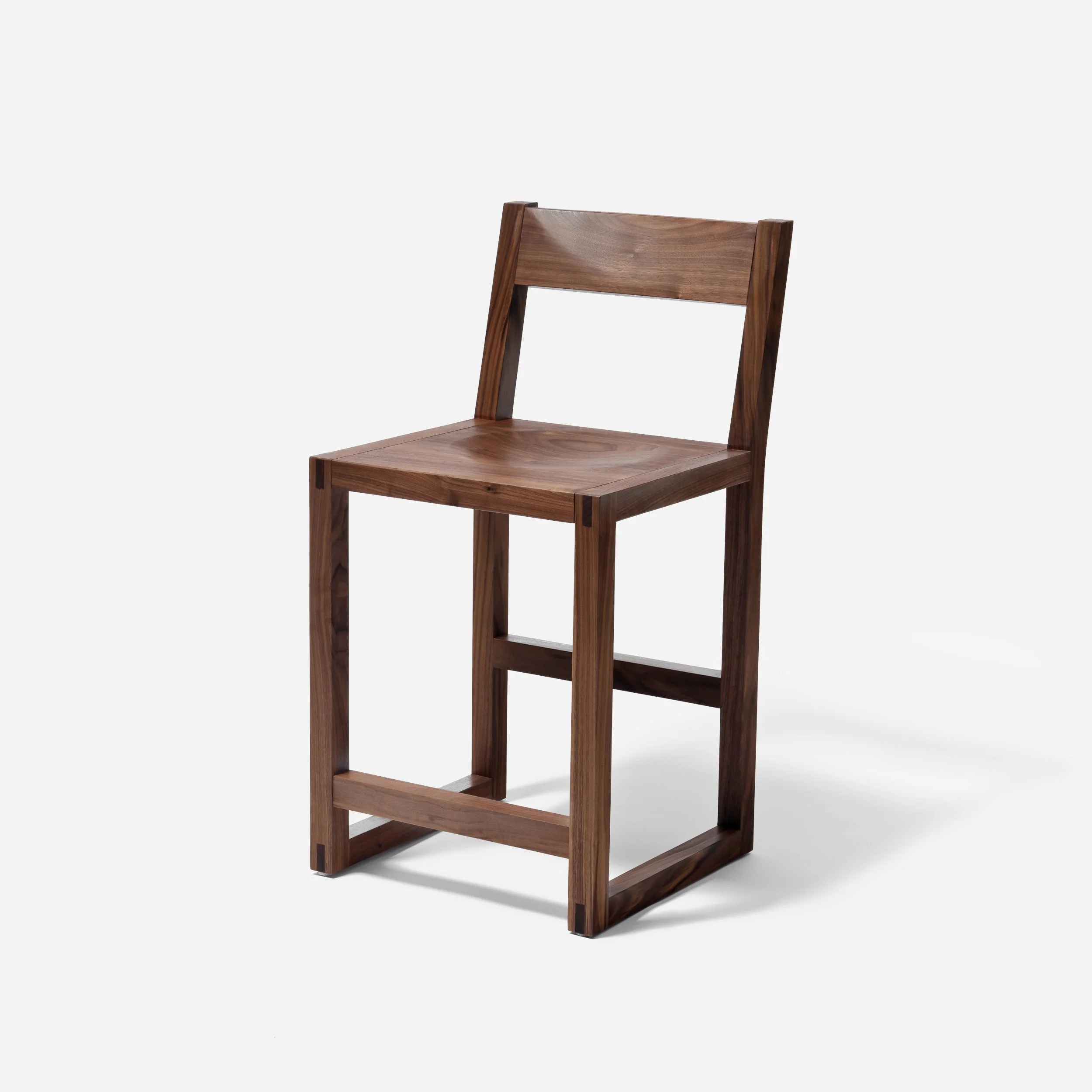 Handcrafted Tressa Bar Stool made from walnut wood with sculpted seat and backrest, traditional bridle joints, modern design, and expert craftsmanship, made in Milwaukee.