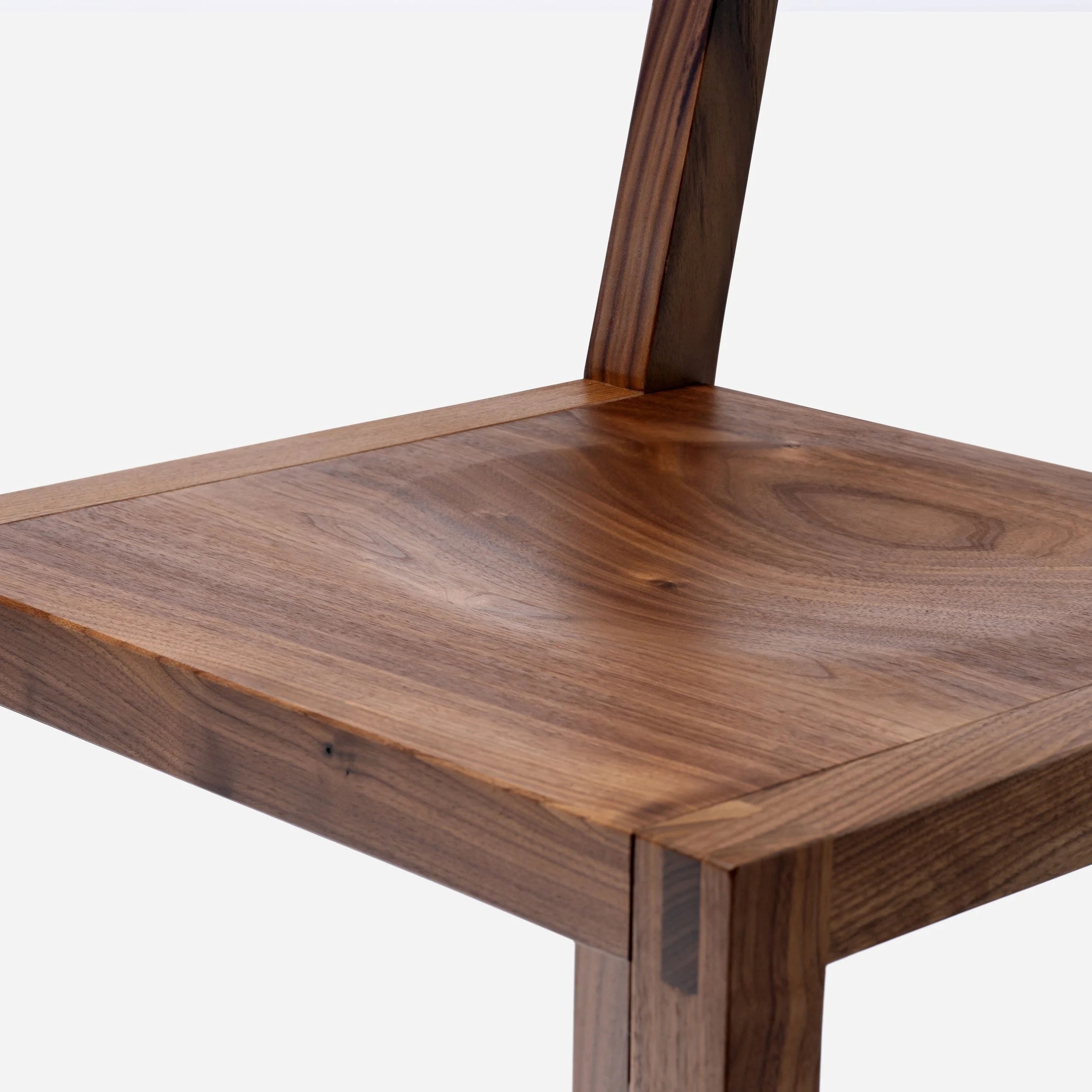 Handcrafted Tressa Bar Stool made from walnut wood with sculpted seat and backrest, traditional bridle joints, modern design, and expert craftsmanship, made in Milwaukee.