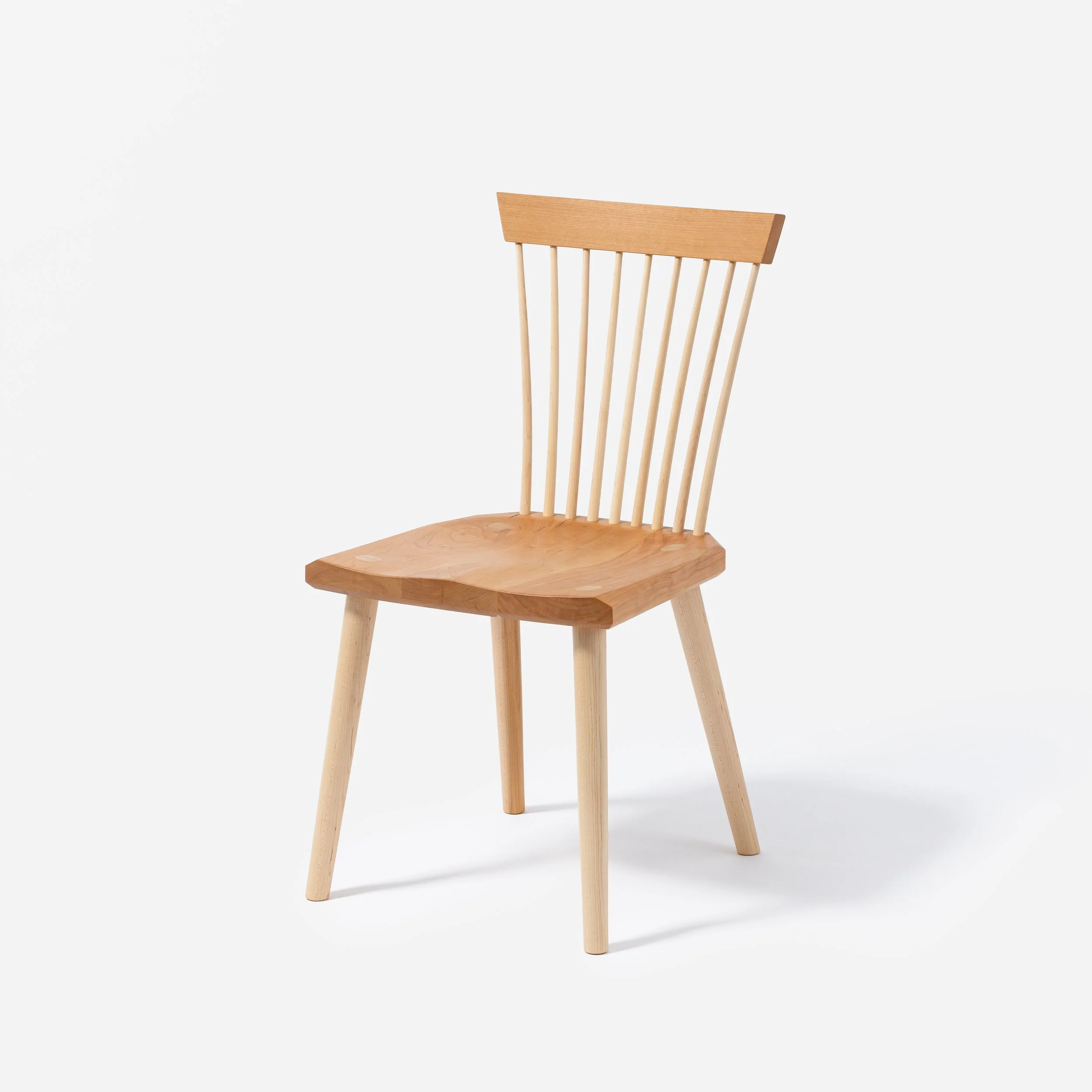 Handcrafted Spindle Back Chair made from cherry wood, offering a sturdy base and timeless aesthetic, made in Milwaukee.