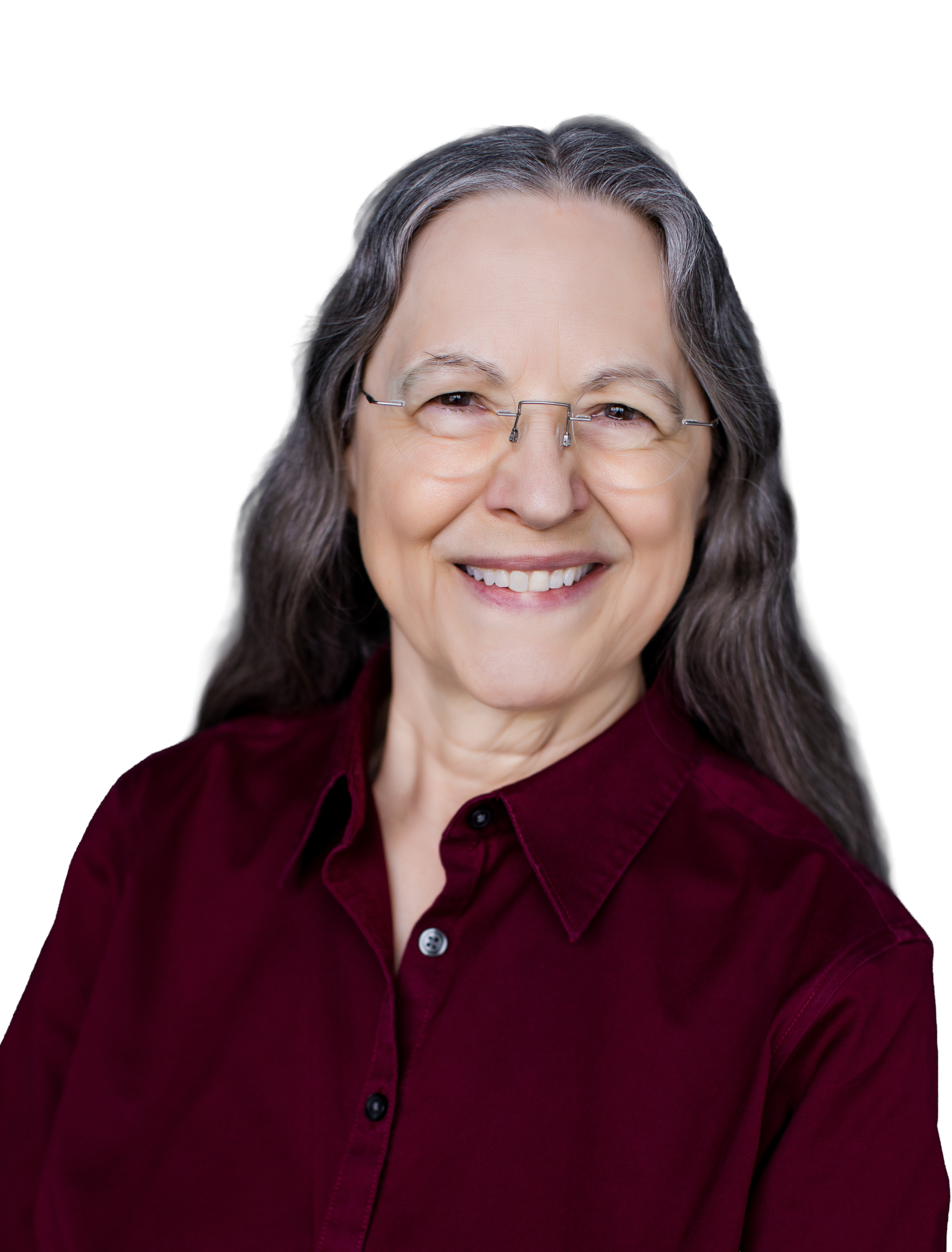 Jackie Blount, smiling, with long gray hair wearing glasses and a maroon blouse against a black background.