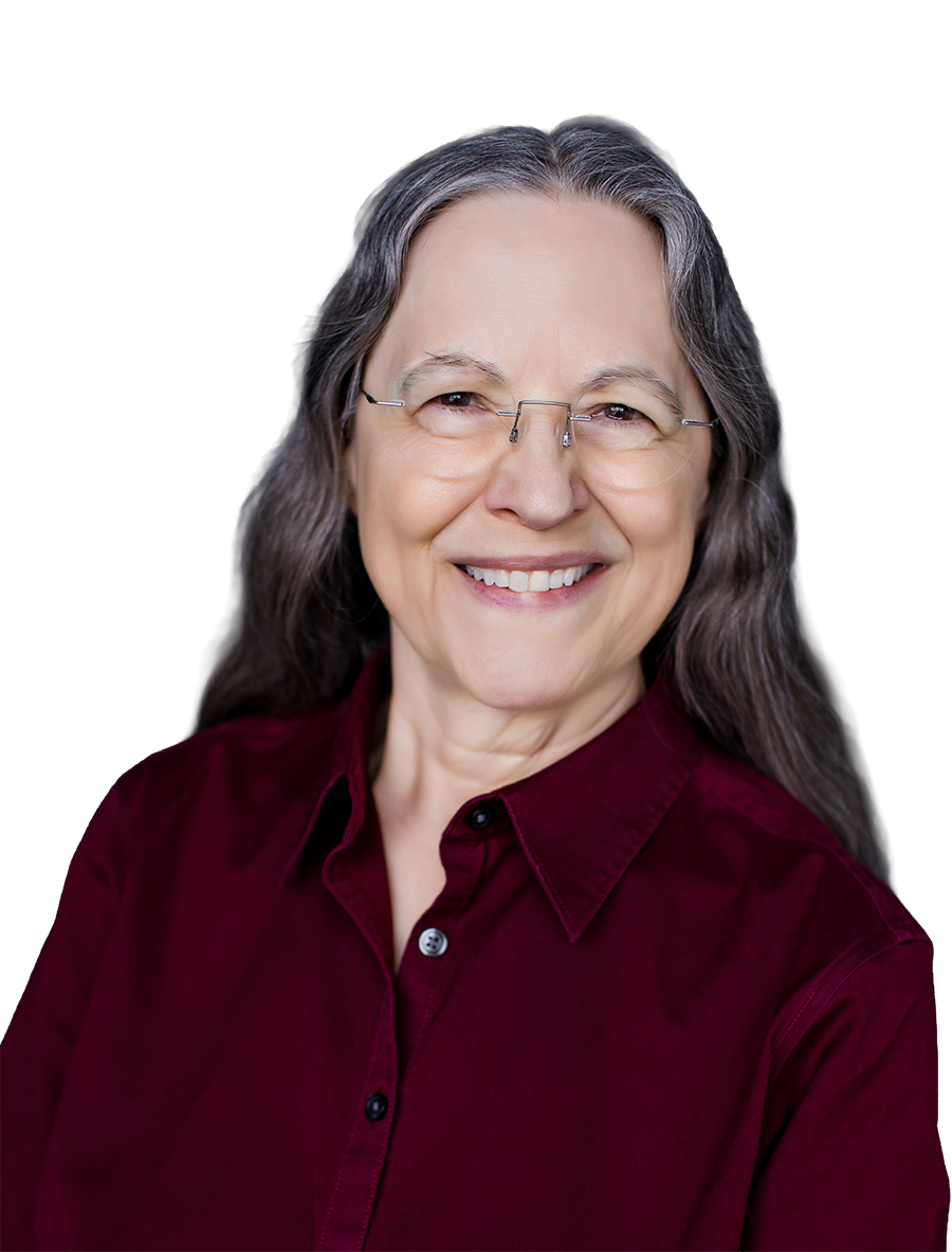 Portrait of Jackie Blount with long gray hair, wearing glasses and a maroon shirt, smiling against a black background.