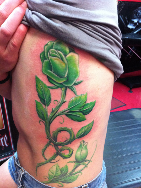 Feminine red roses  green leaves tattoo on forearm