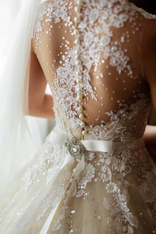 Sheer wedding dress embellished with pearls and rhinestone crystals.