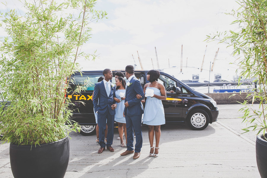 Ushers and bridesmaids arrive in a London taxi