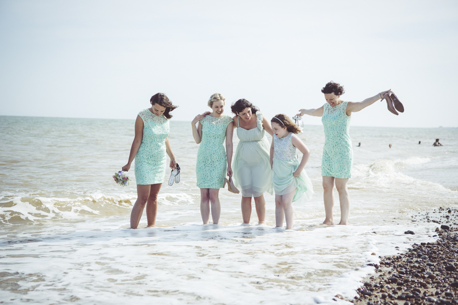 Bridesmaids dipping their toes in the sea