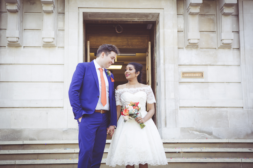 Bride and groom on steps of Hackney Town Hall