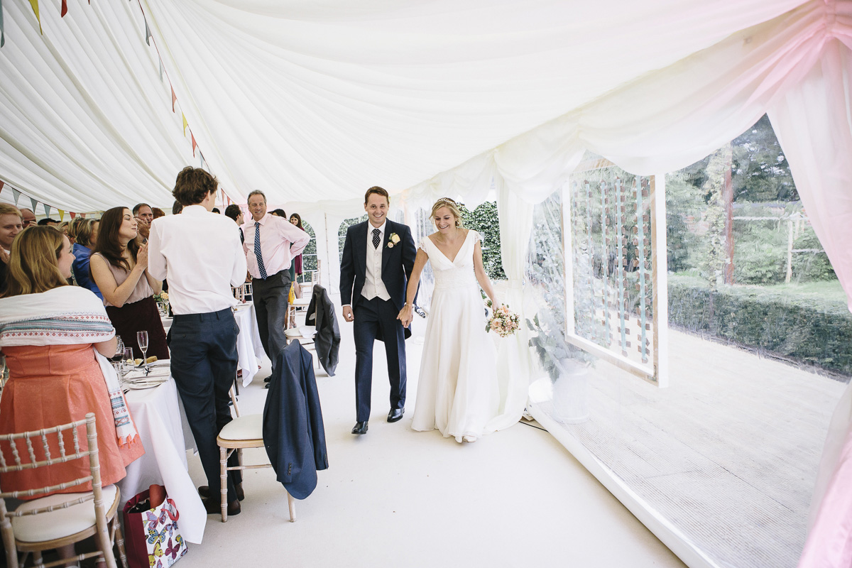bride and groom enter the marquee