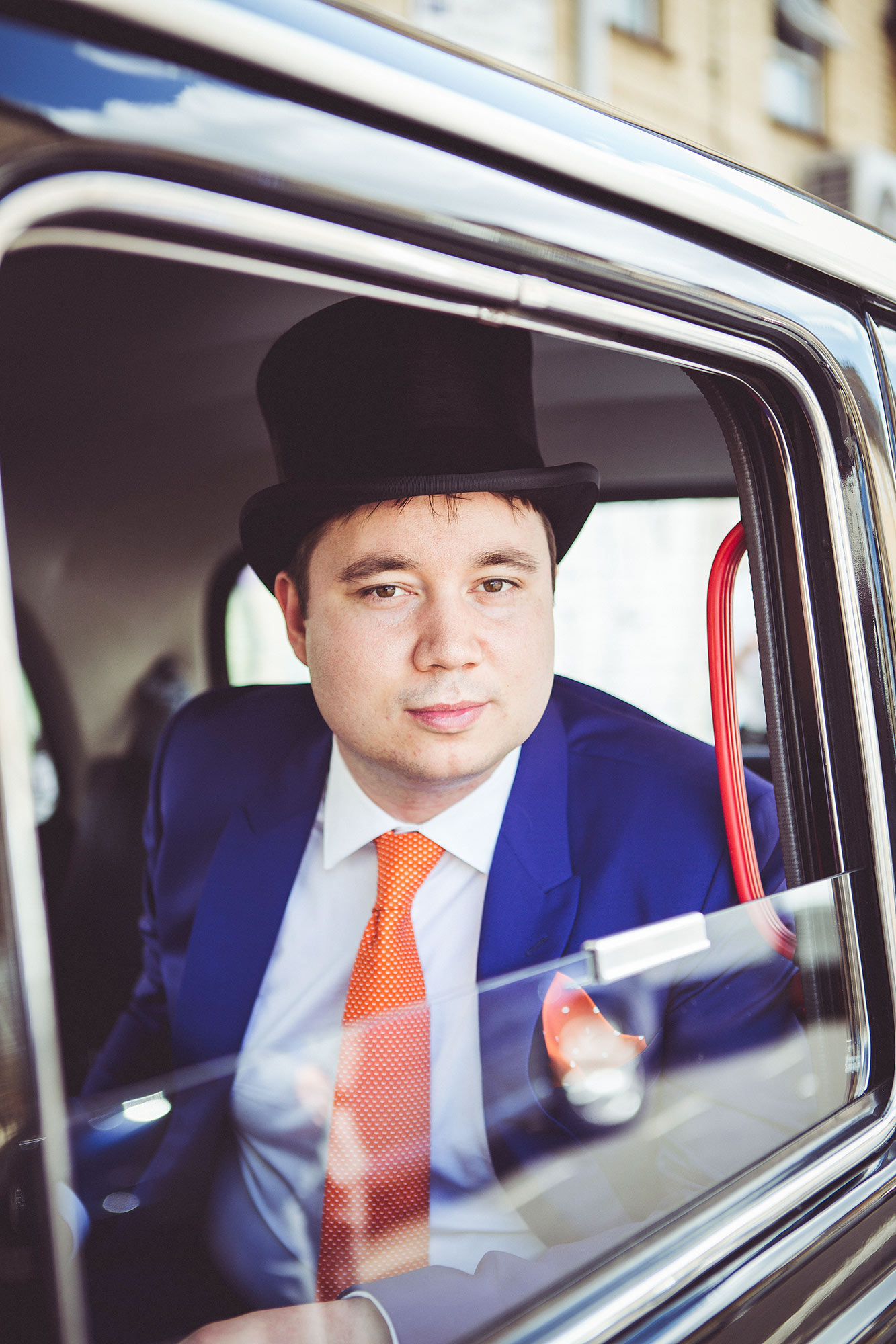  Groom in london taxi wearing a top hat 