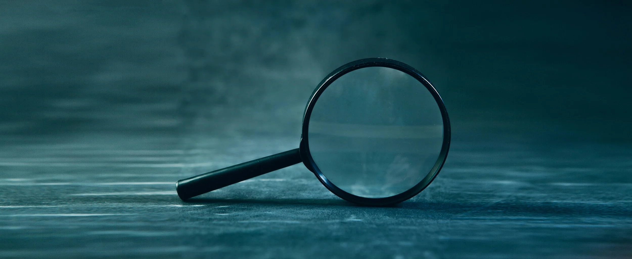 A magnifying glass rests on a textured surface-Sasun Bughdaryan-Unsplash.jpg