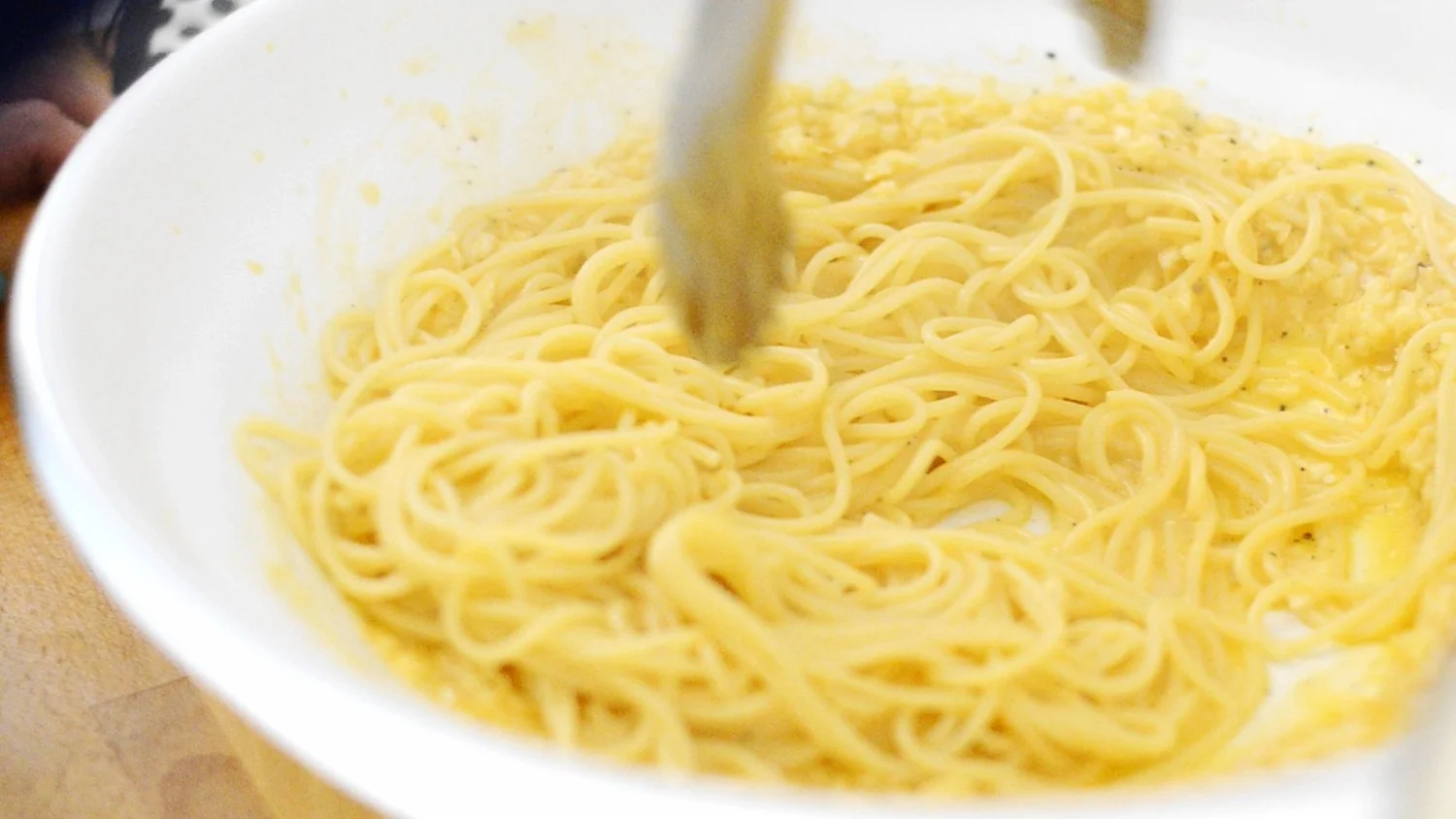 Pasta unter die Ei-Pecorino-Mischung heben