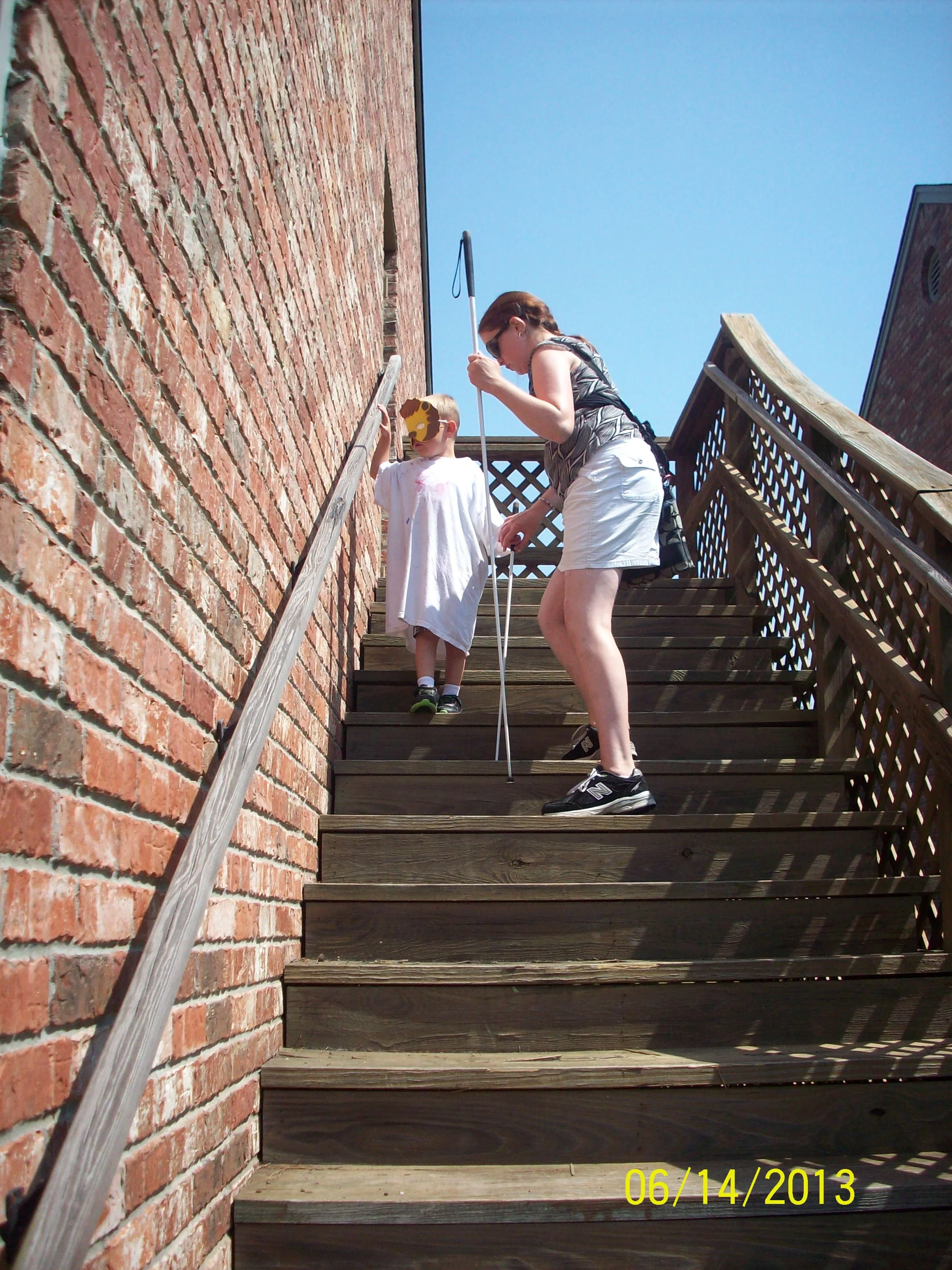 Domonique teaches Isaiah cane techniques on the stairs