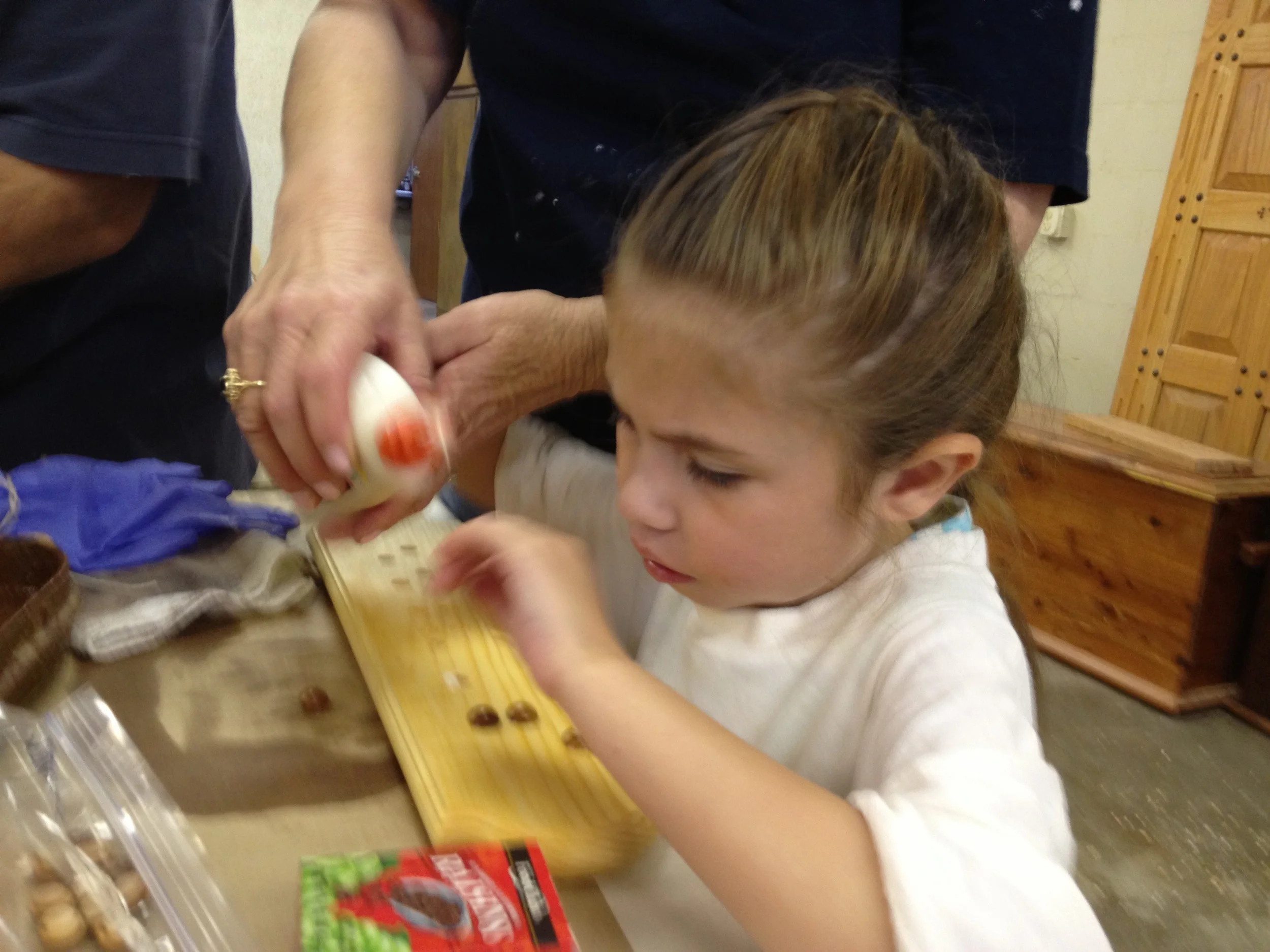 Baylee glues the dials to create her braille name plaque
