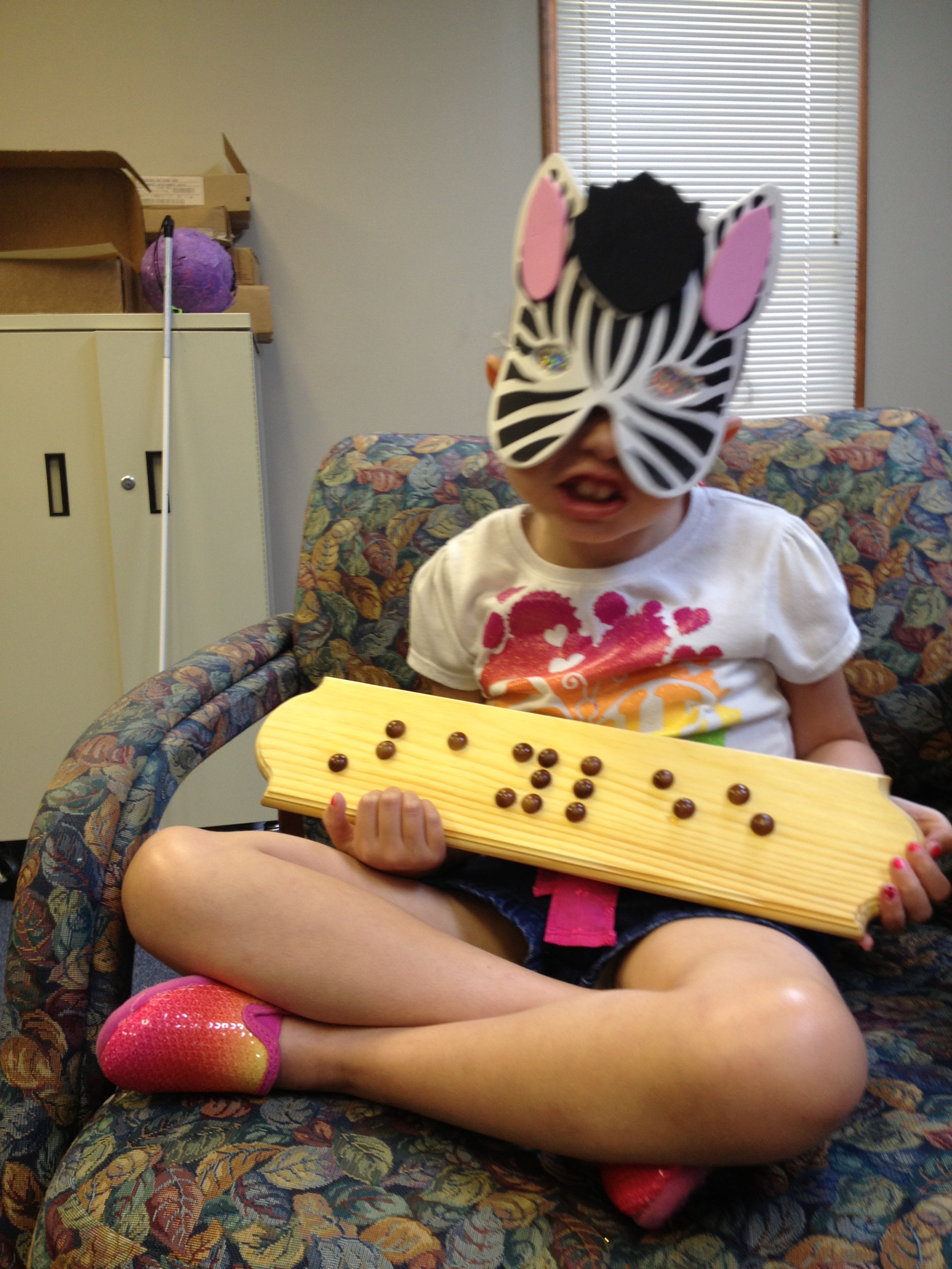 Baylee with her finished braille name plaque