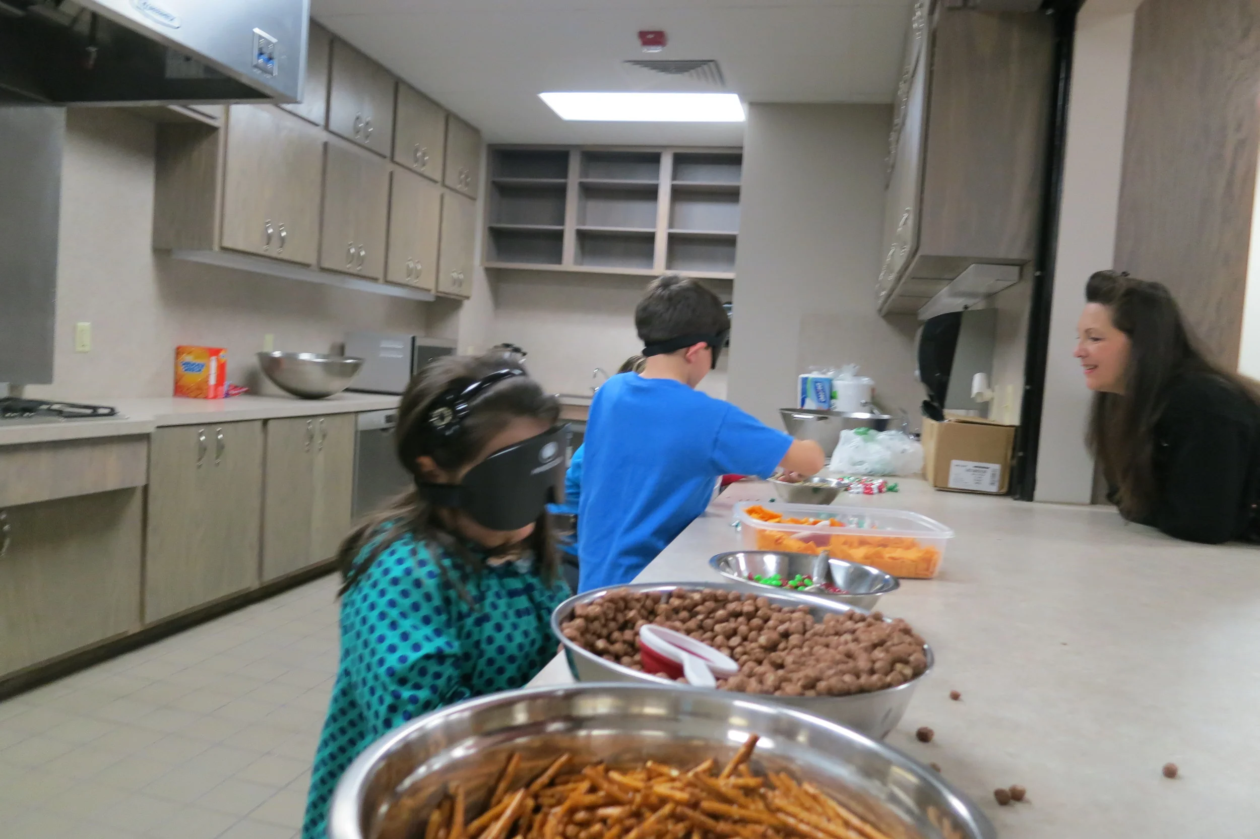 Bri and Austin make Braille Trail Mix under sleepshades