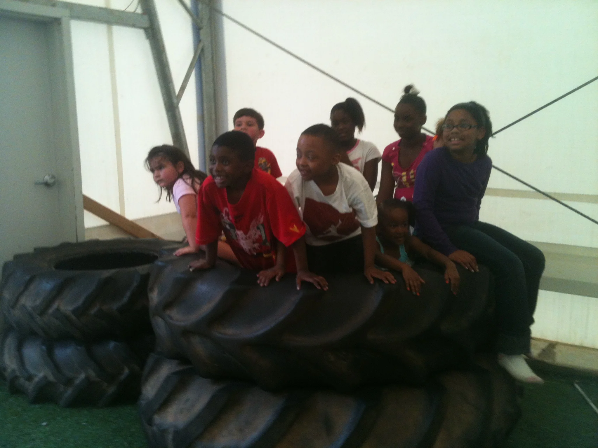 Saturday Club crew poses for a picture on a huge tire