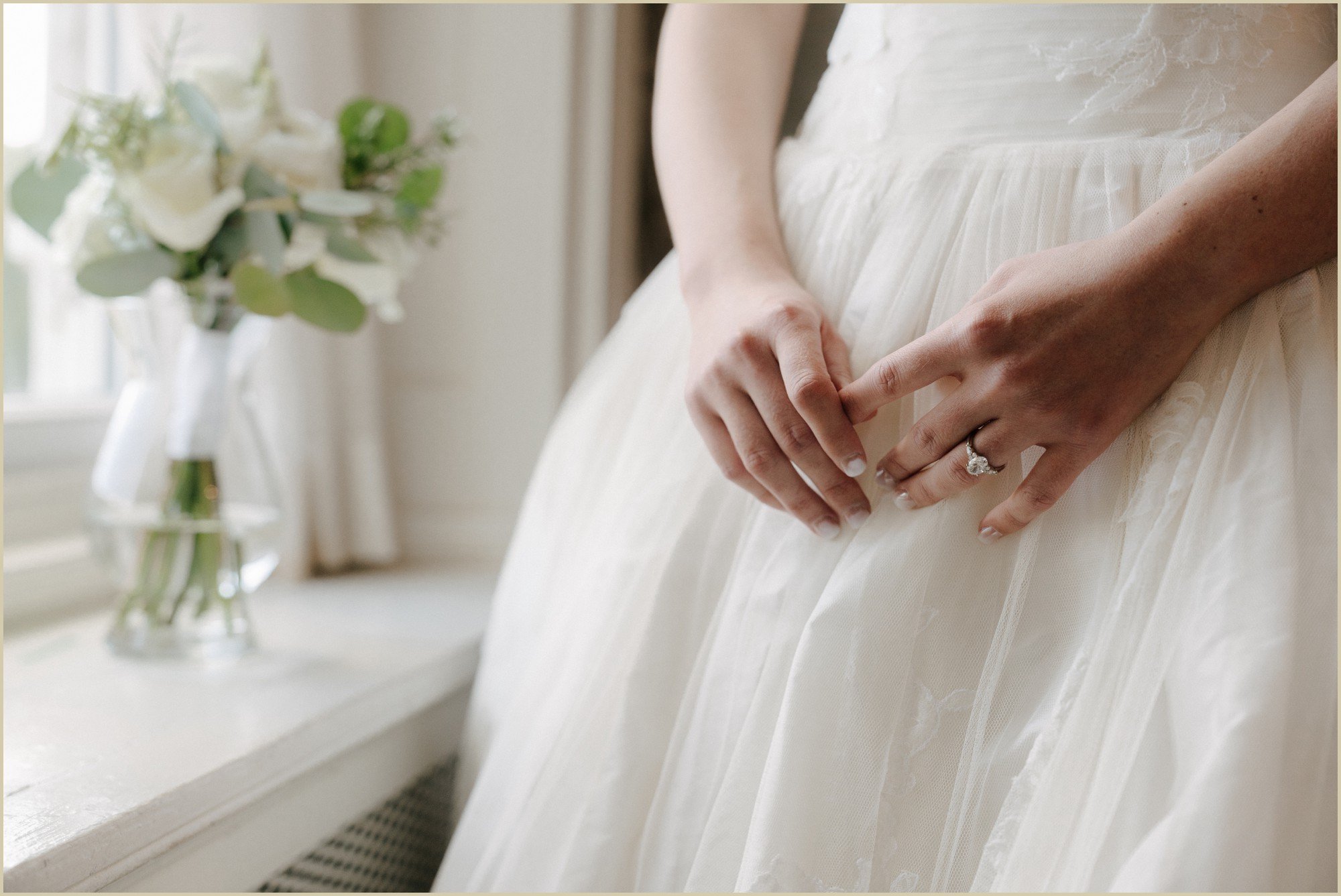 detail of bride's ring and wedding dress