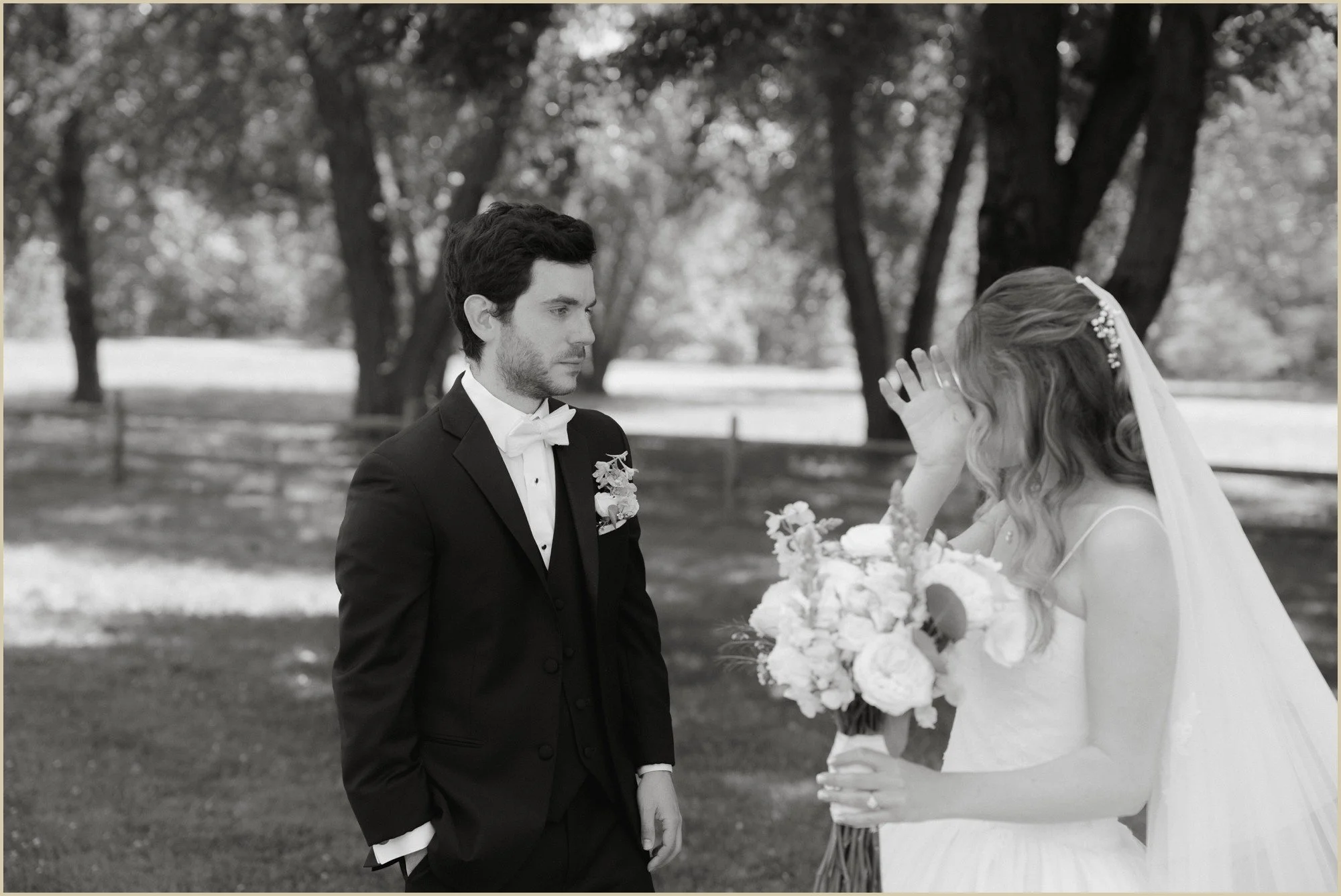 black and white photo of bride wiping tear