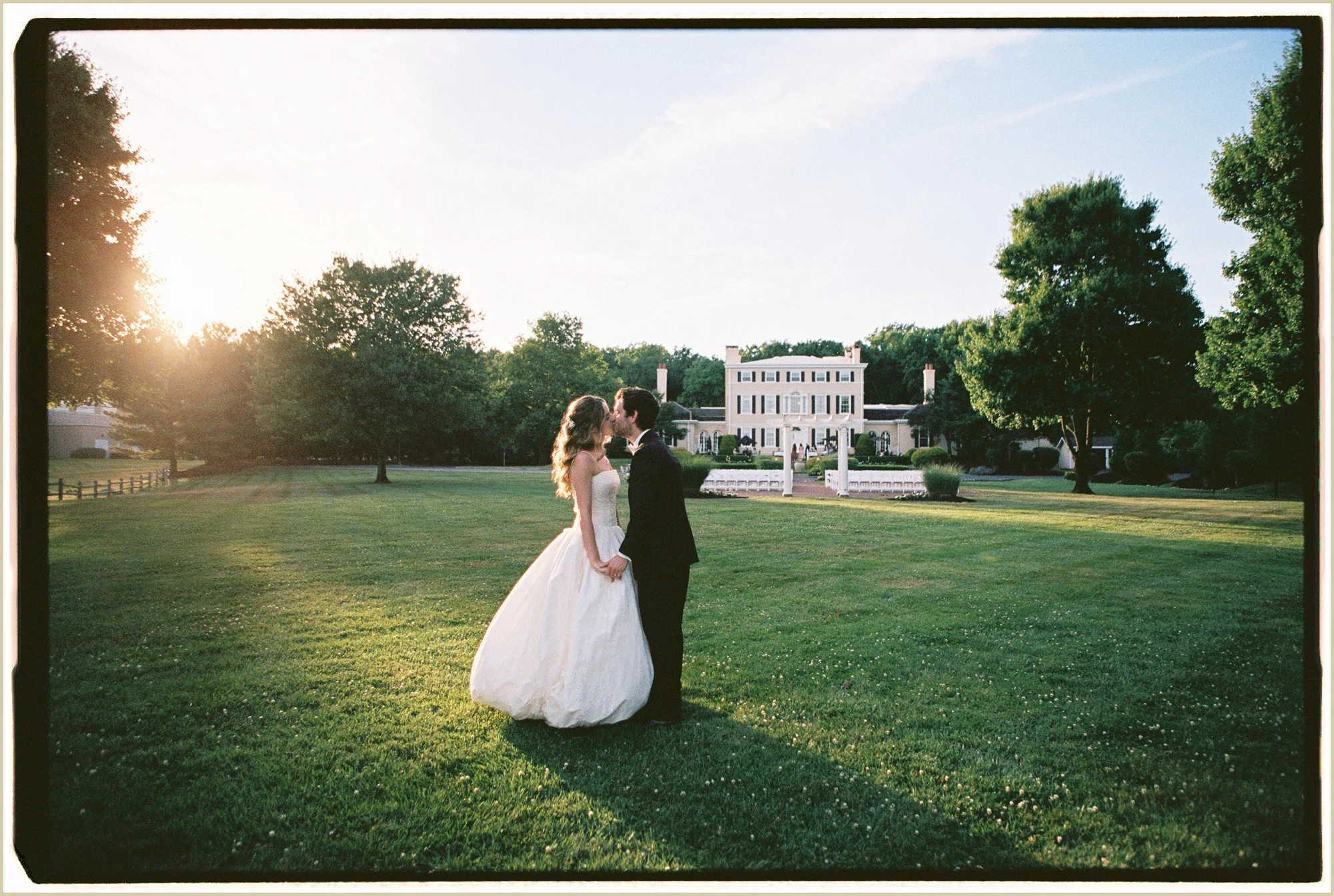 golden hour film wedding photos of bride and groom kissing