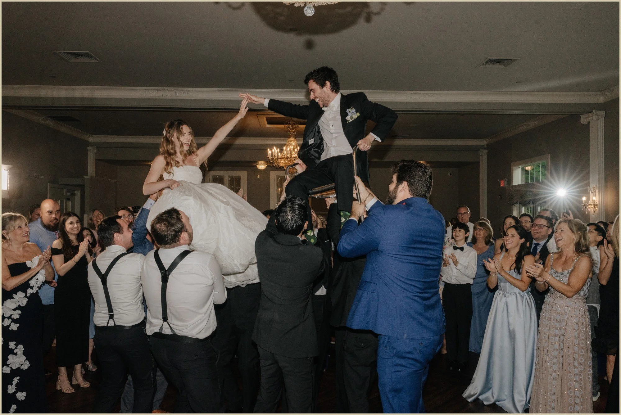 bride and groom being lifted during the hora