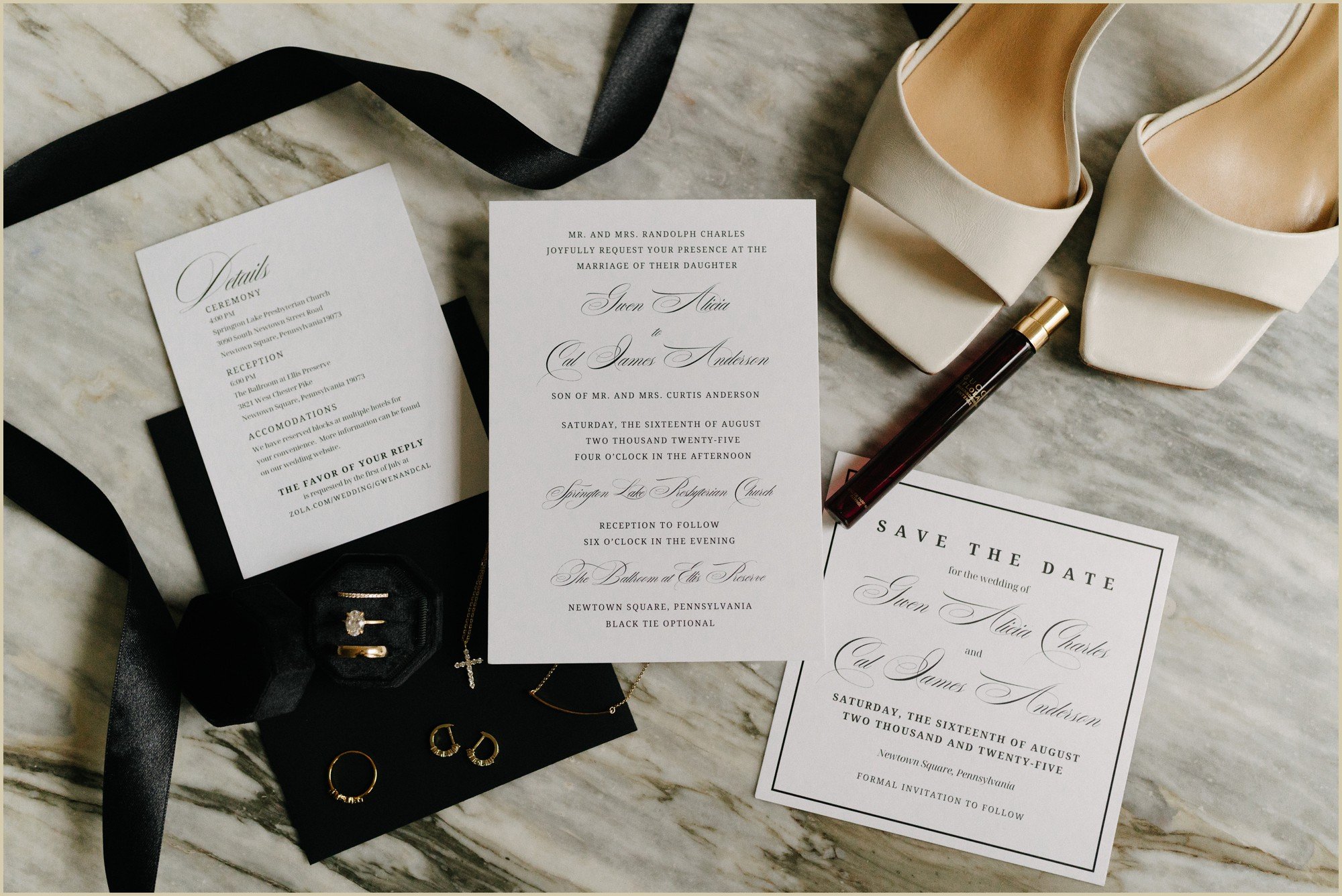 an invitation suite flat lay with black details
